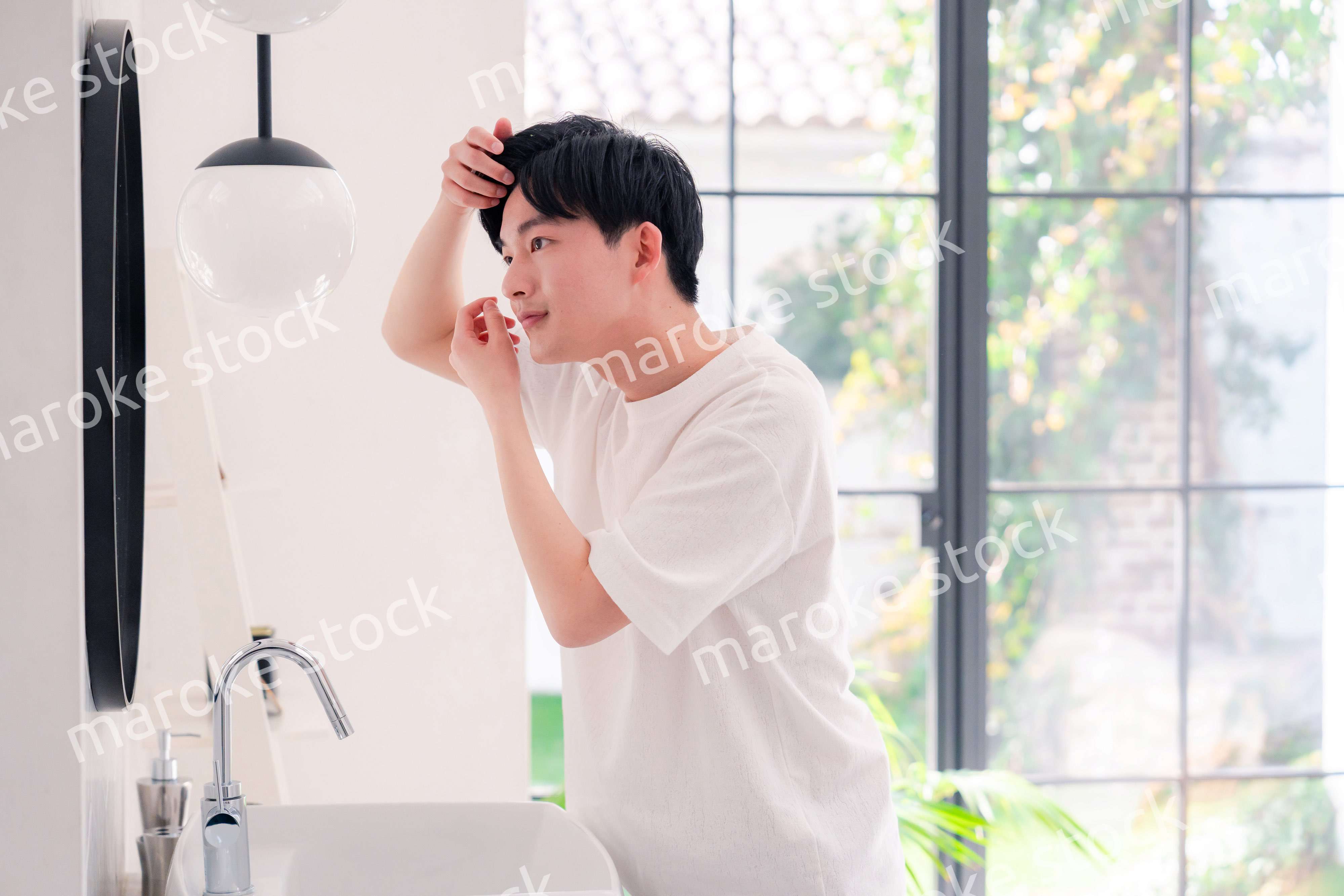 洗面所で身だしなみを整える若い男性