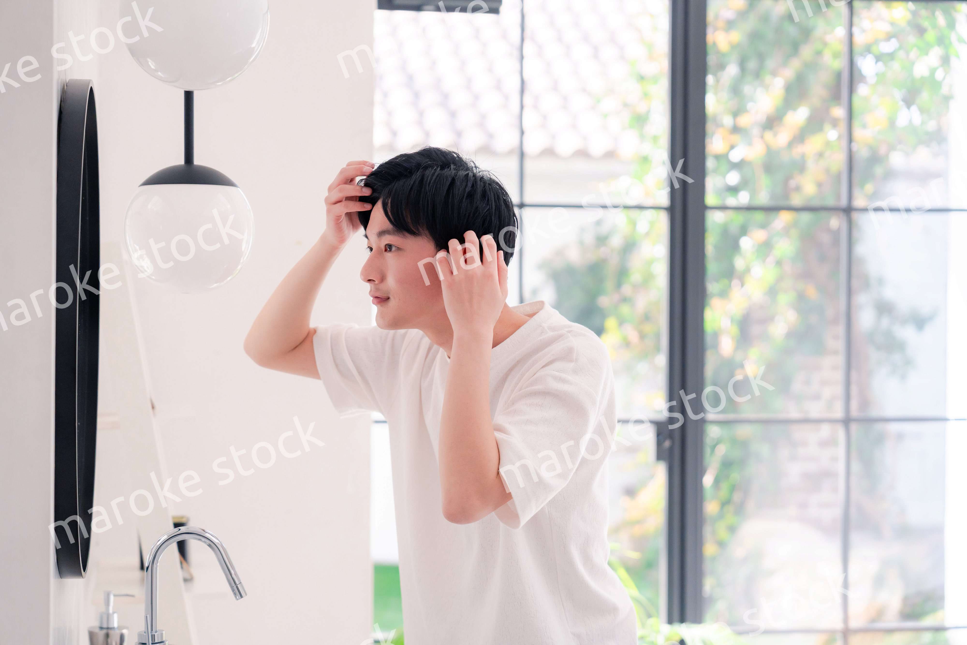 洗面所で身だしなみを整える若い男性