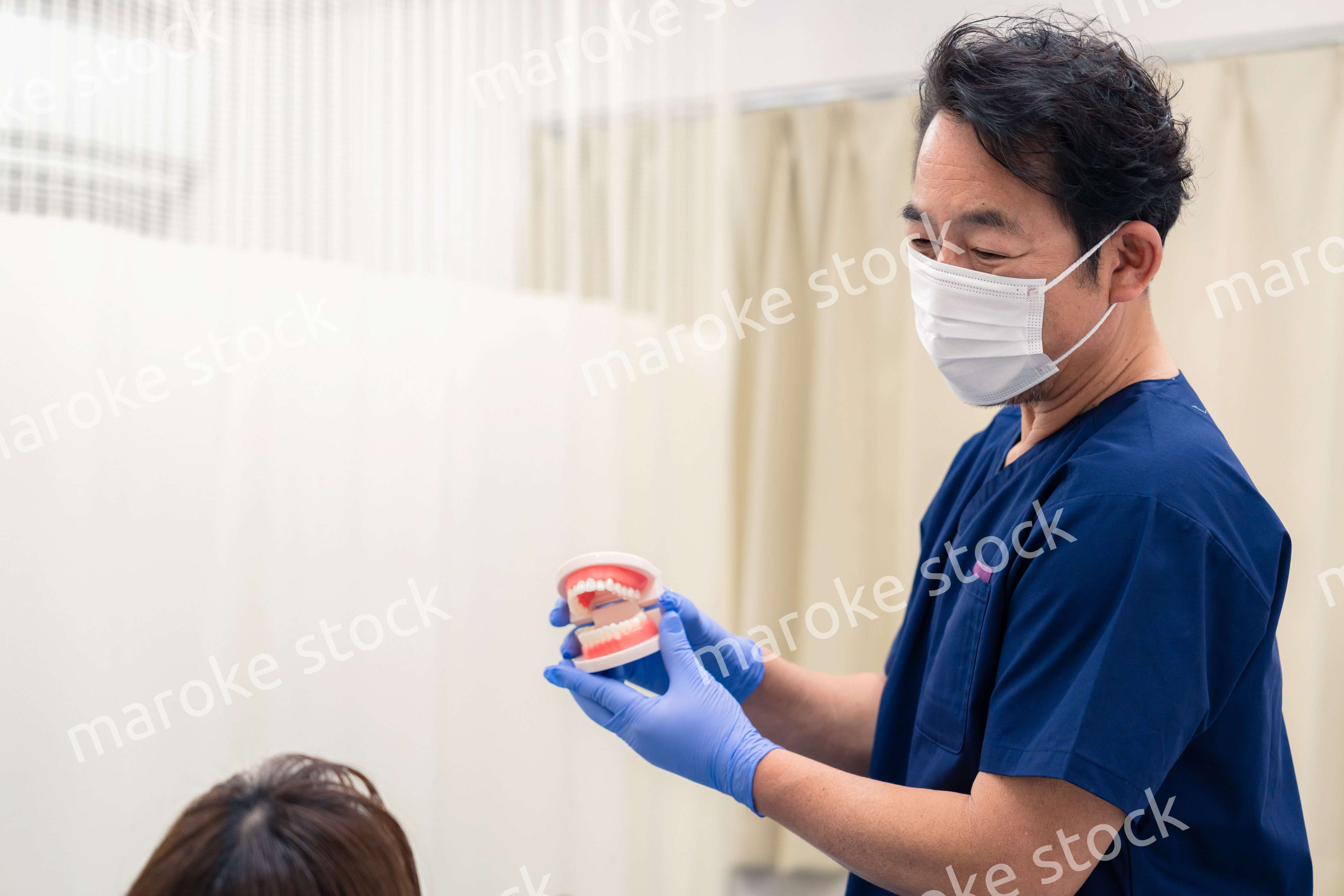 患者に治療方針を説明する歯科医師