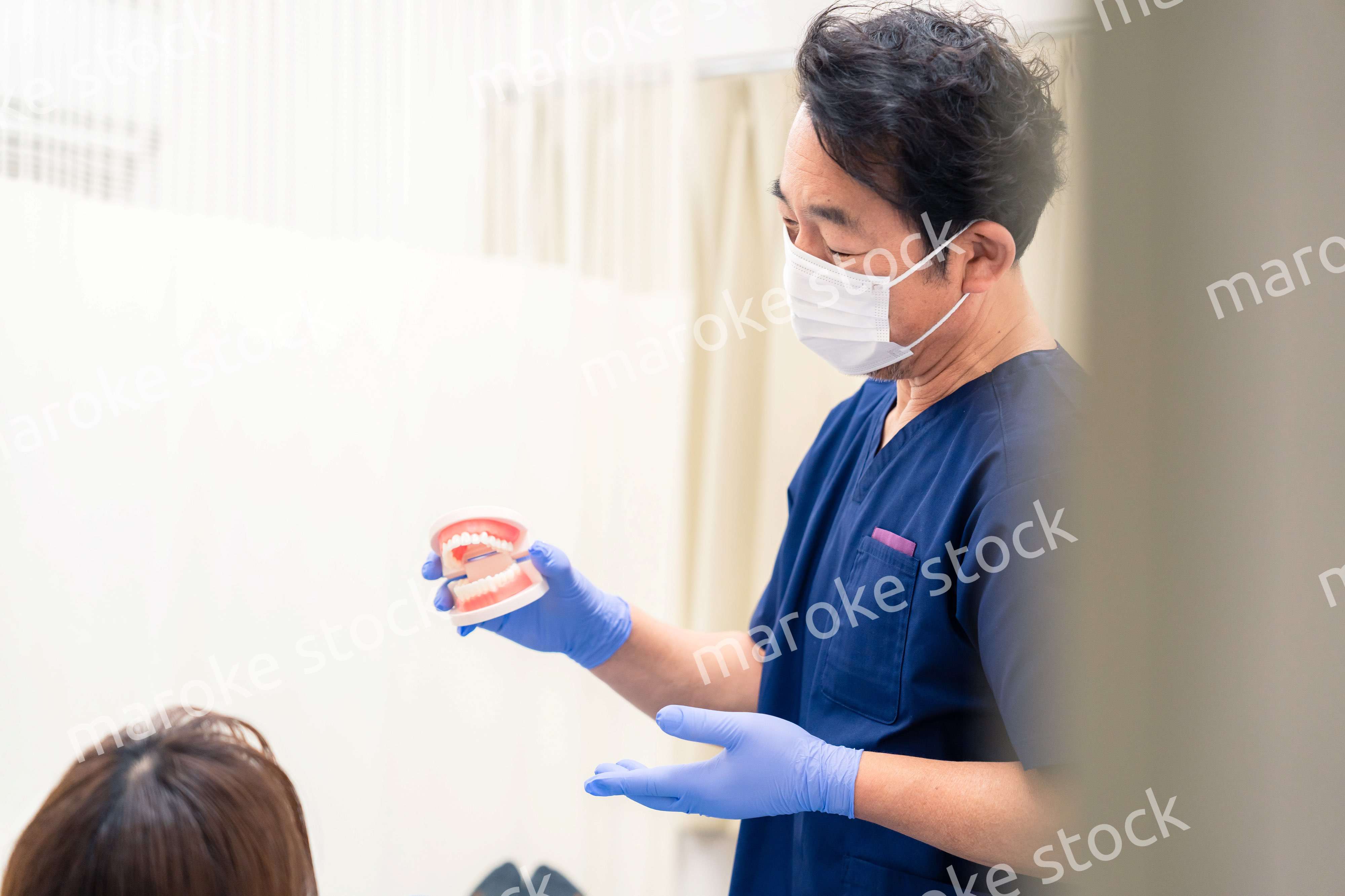 患者に治療方針を説明する歯科医師