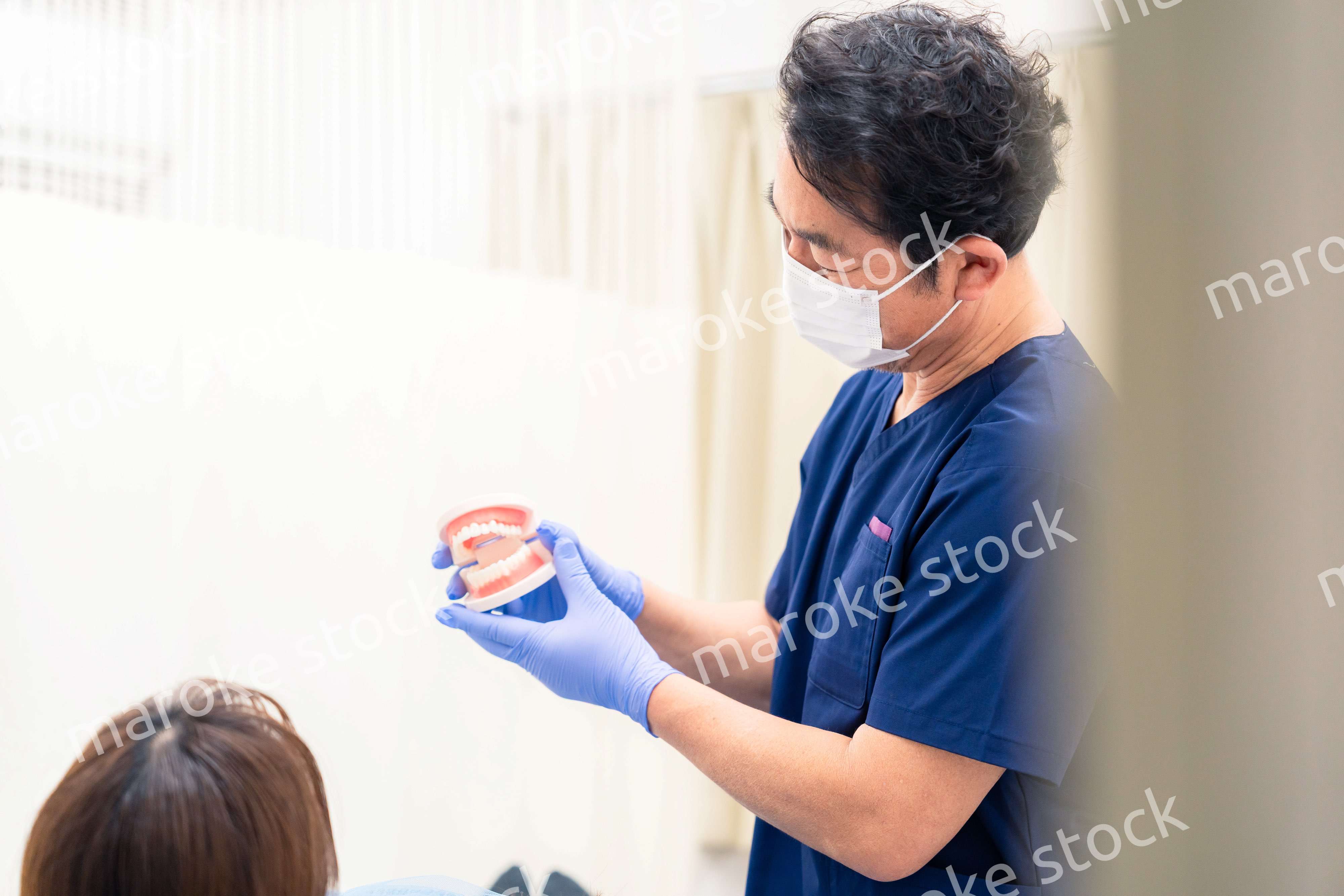 患者に治療方針を説明する歯科医師