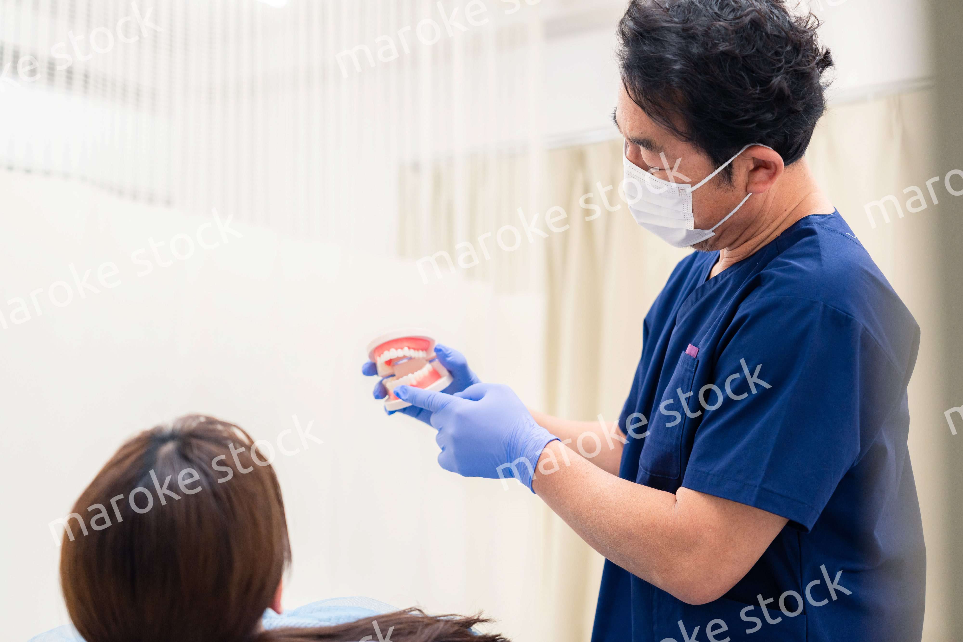 患者に治療方針を説明する歯科医師