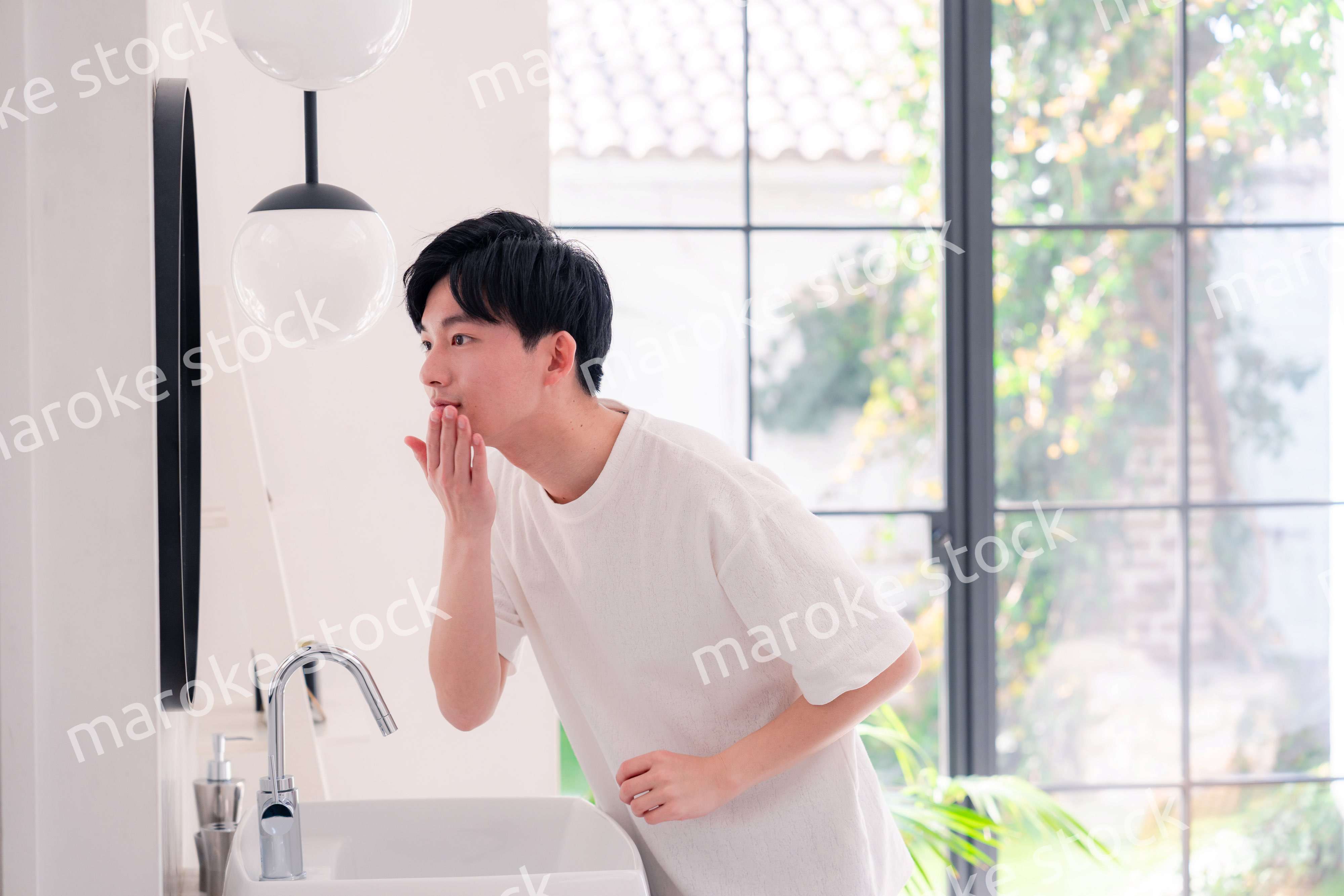 洗面所で身だしなみを整える若い男性