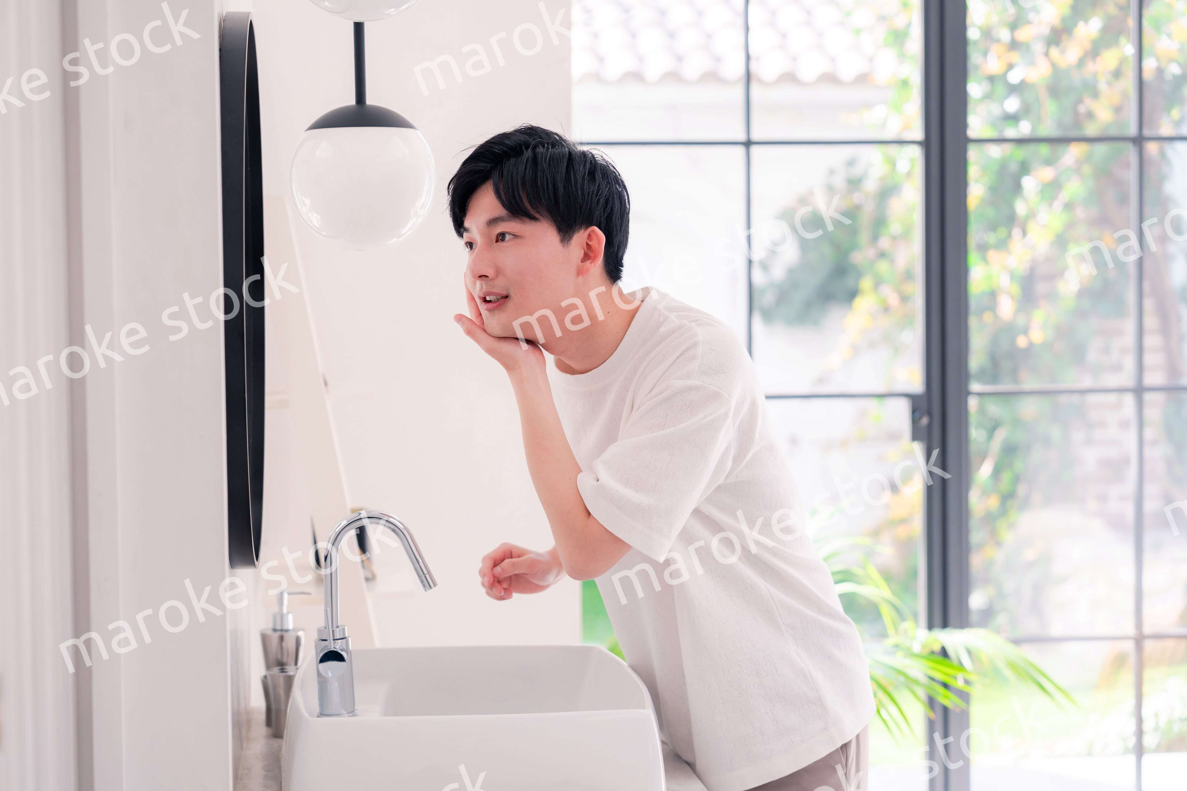 洗面所で身だしなみを整える若い男性