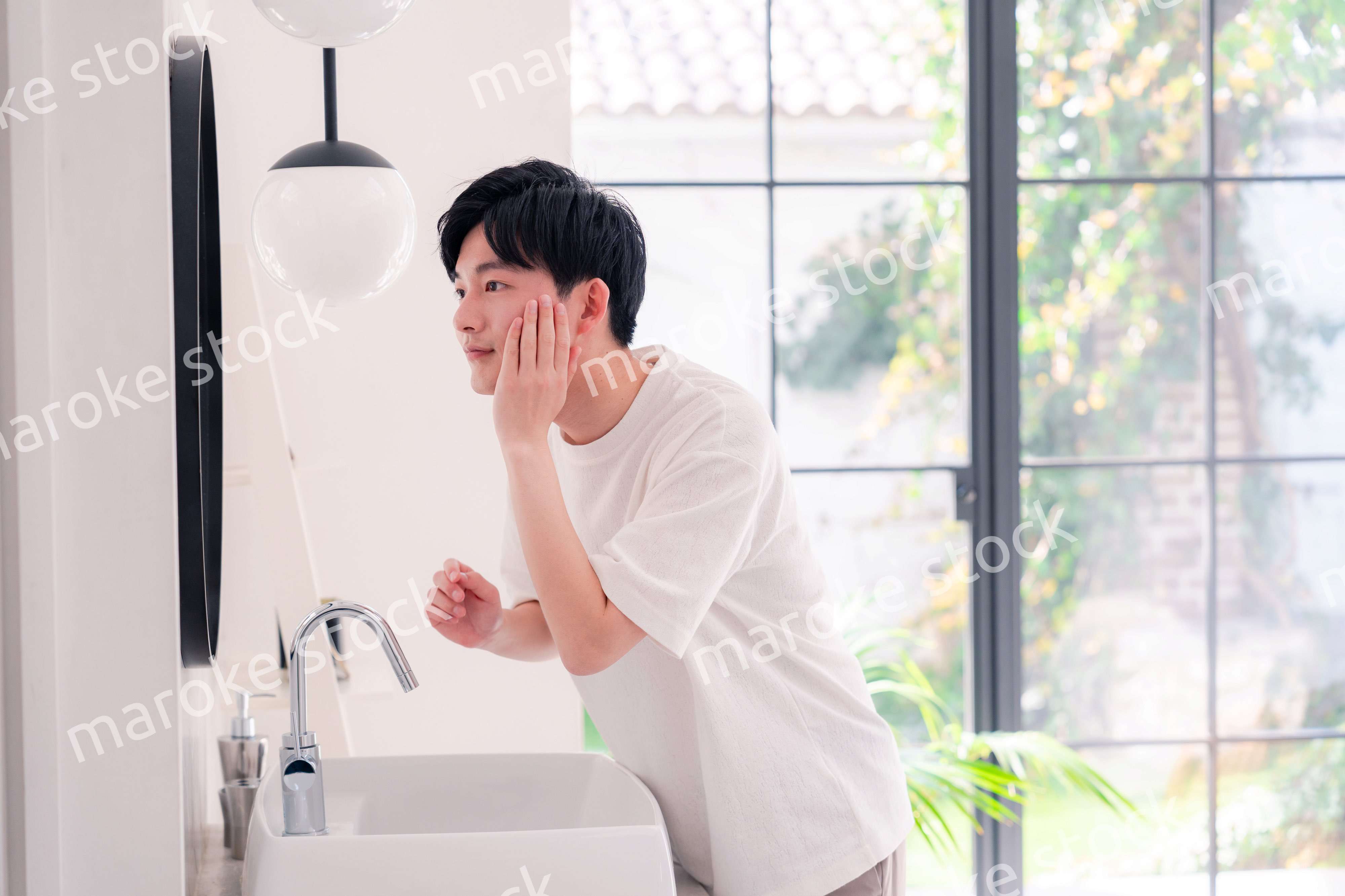 洗面所で身だしなみを整える若い男性