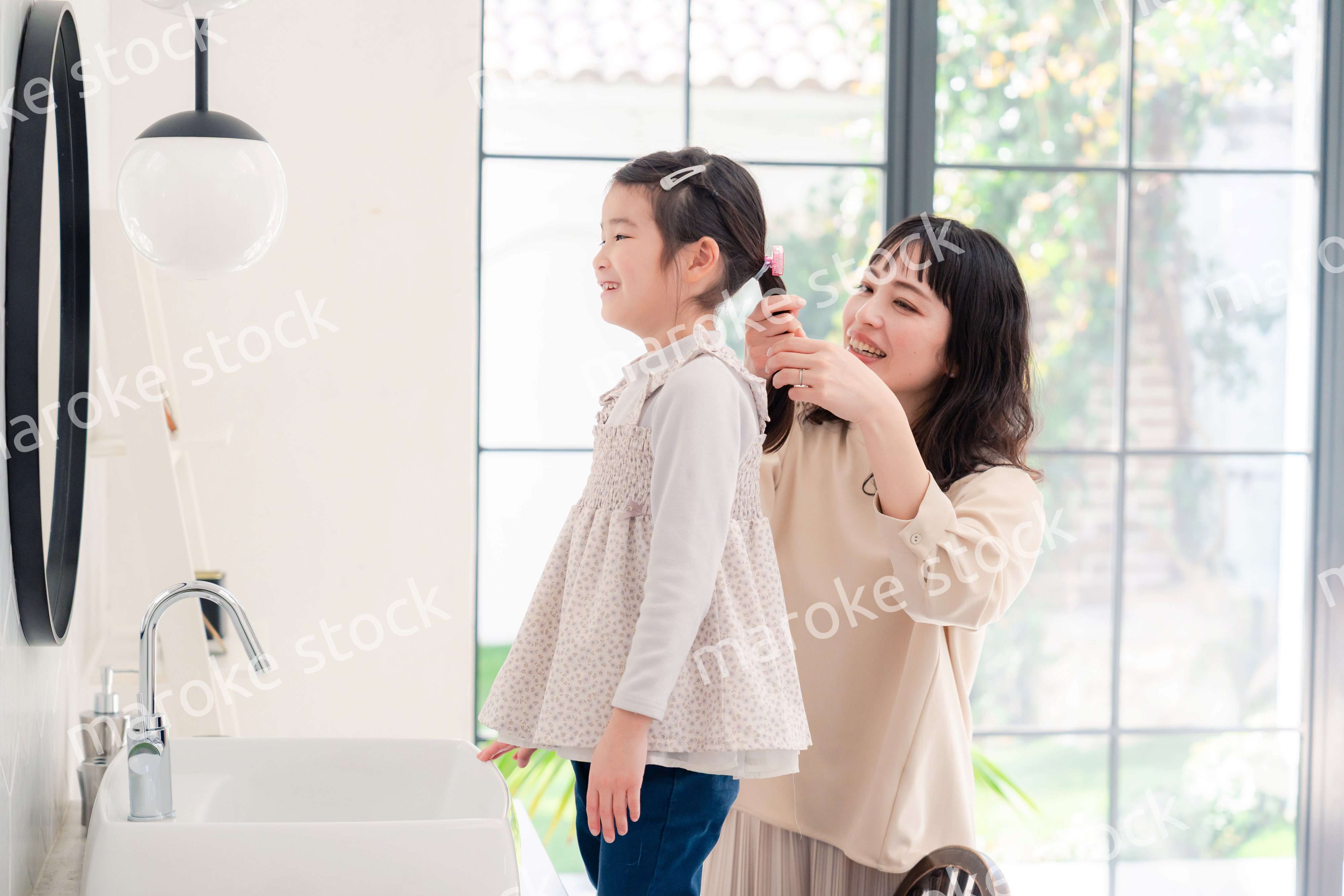 子供の髪の毛をセットするお母さん