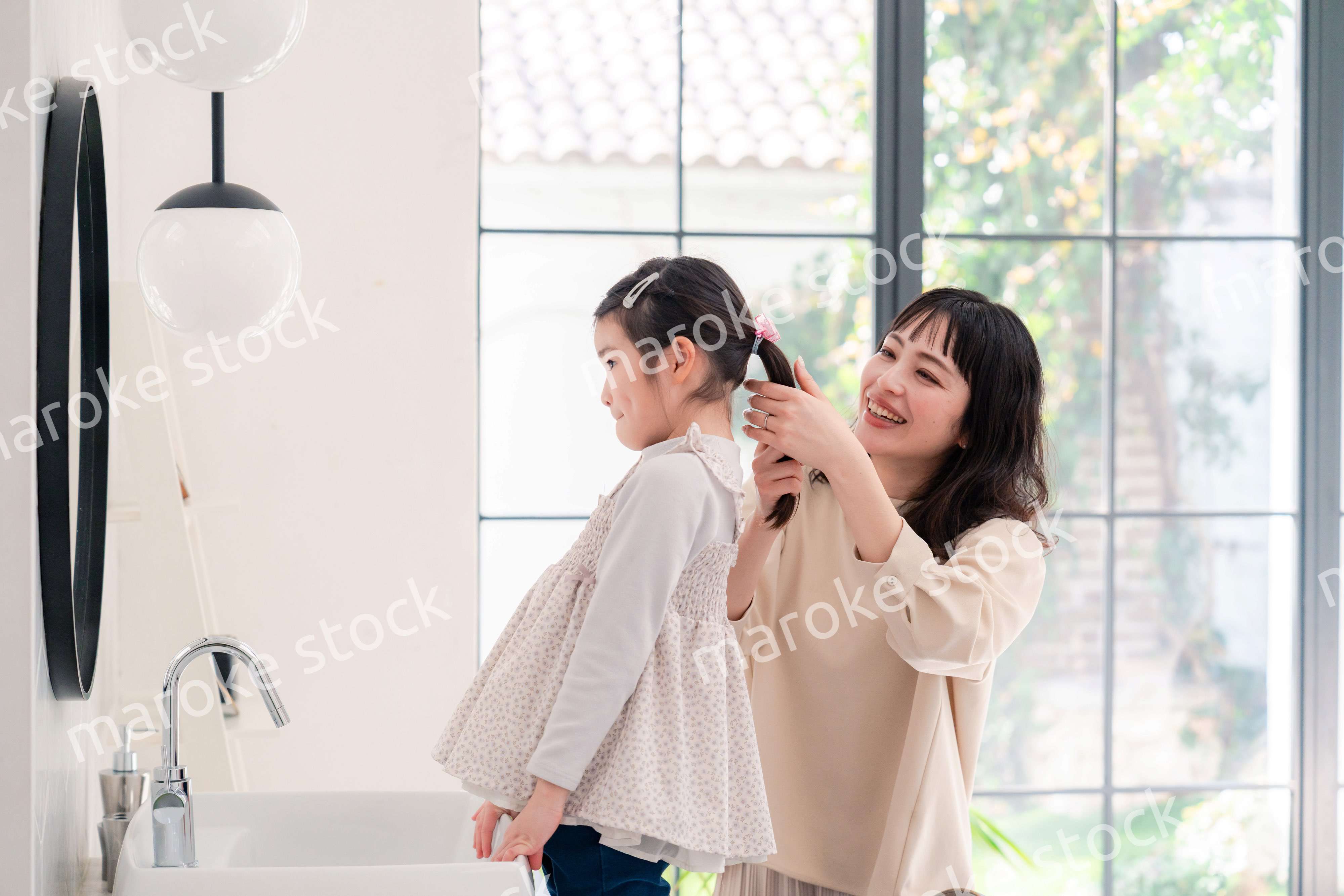 子供の髪の毛をセットするお母さん