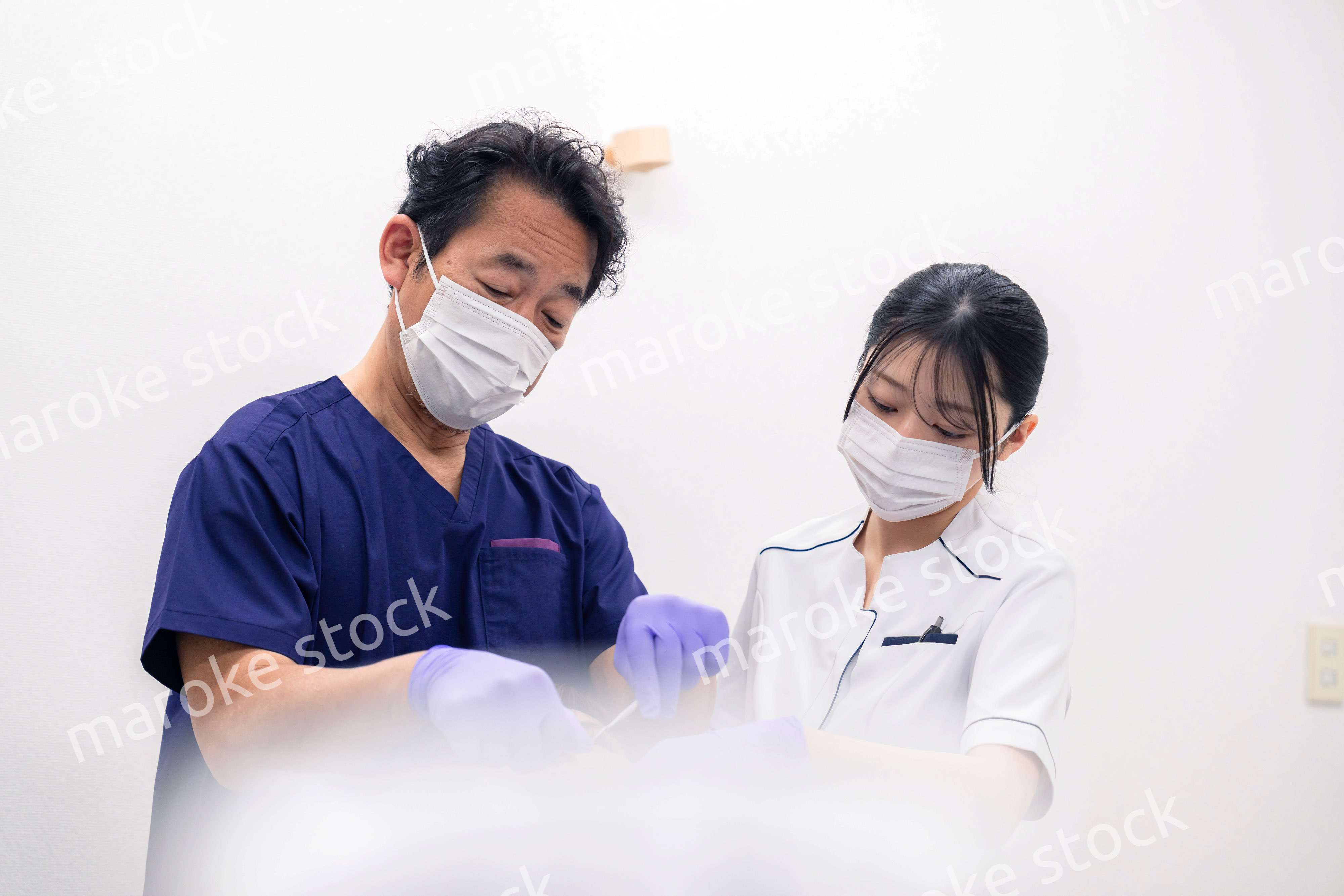 歯科治療をする歯科医師と歯科助手