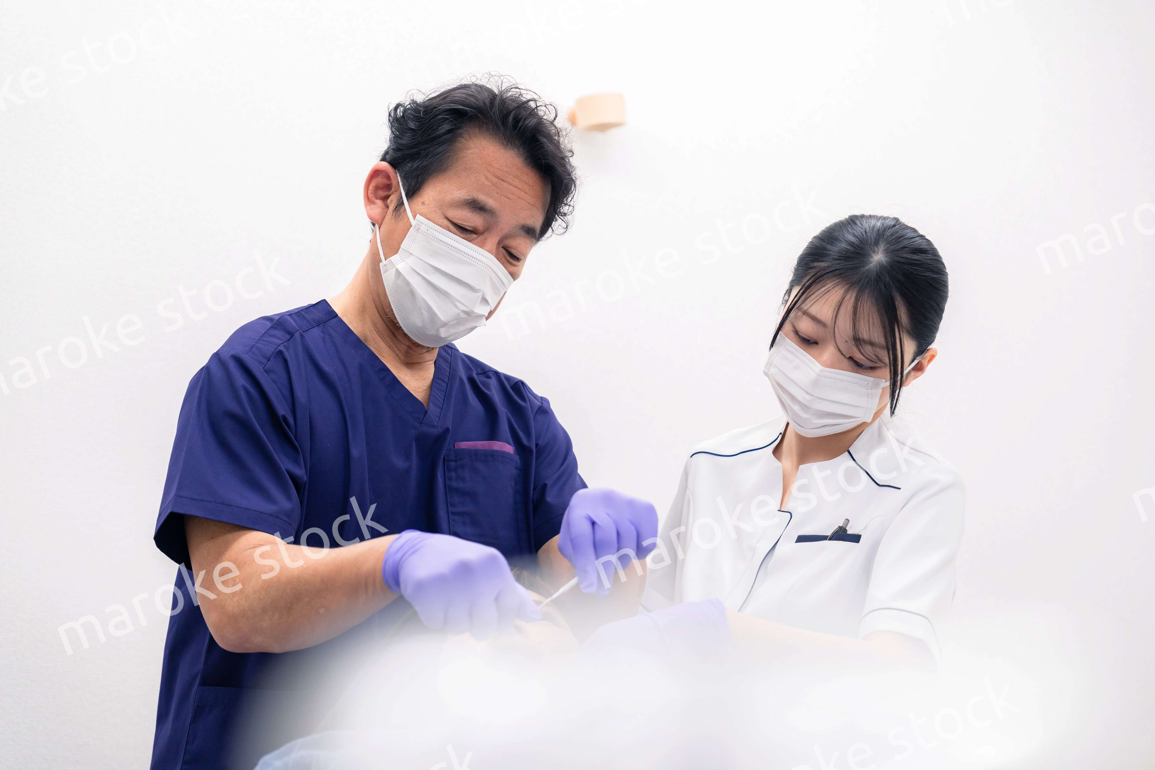 歯科治療をする歯科医師と歯科助手