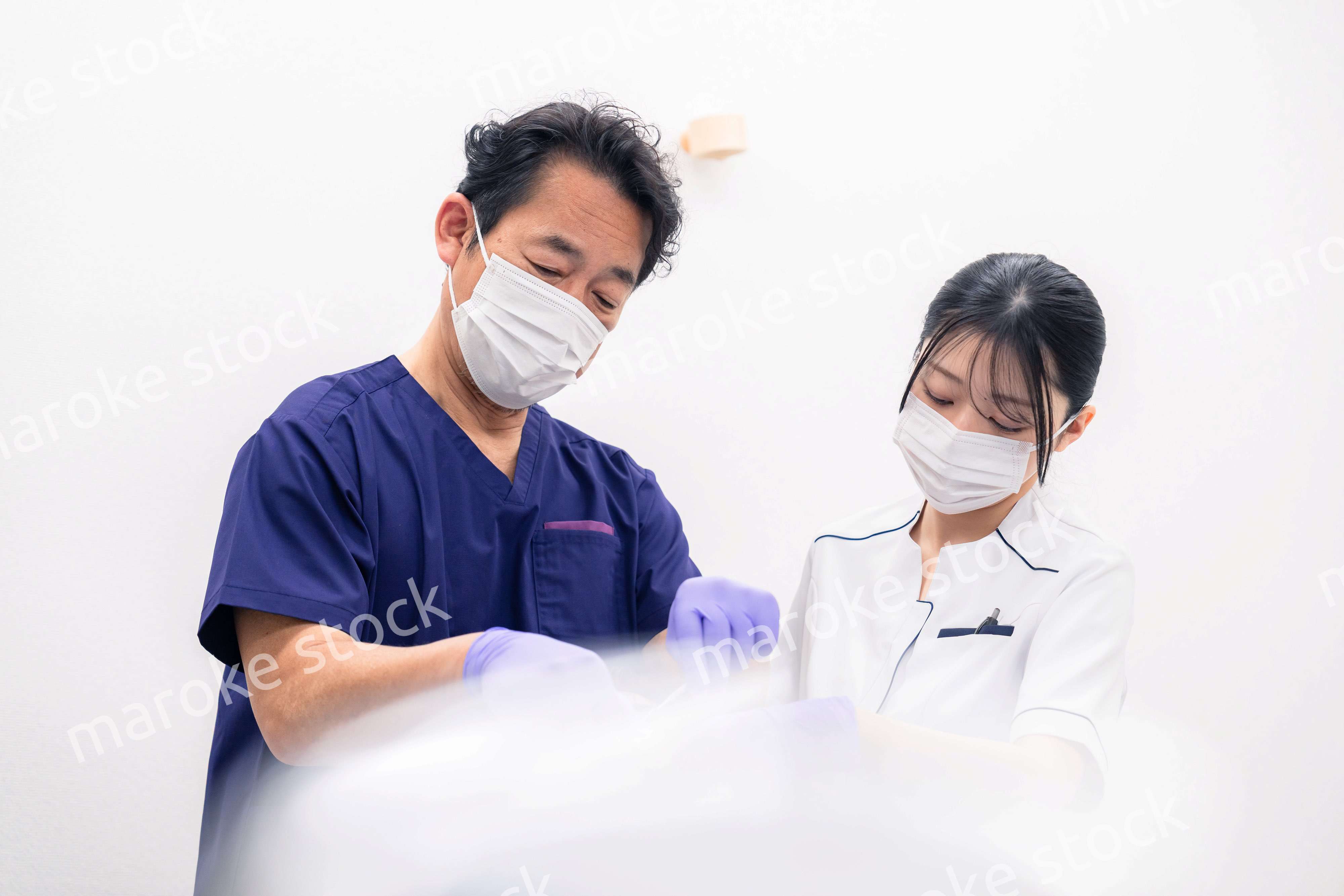 歯科治療をする歯科医師と歯科助手