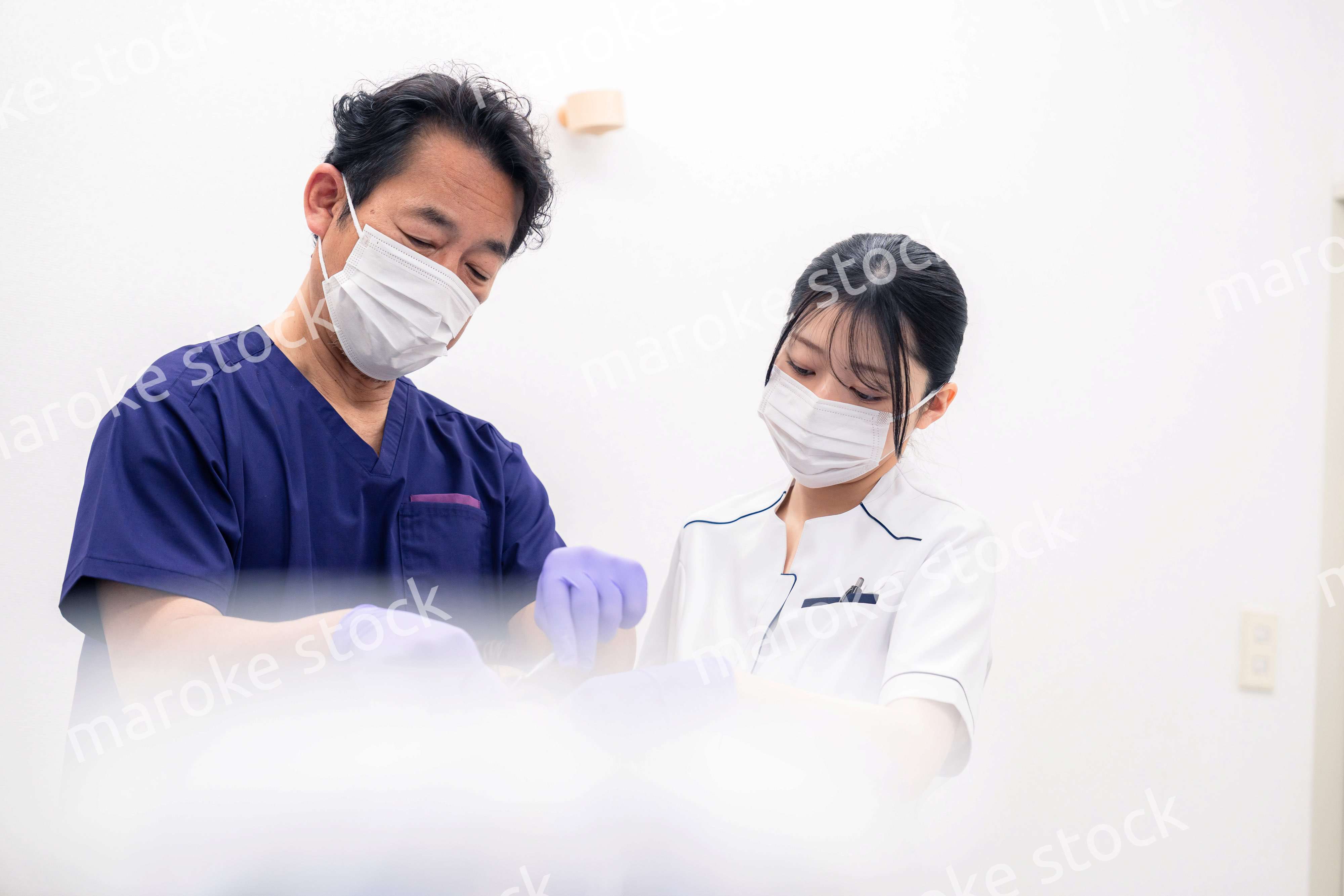歯科治療をする歯科医師と歯科助手
