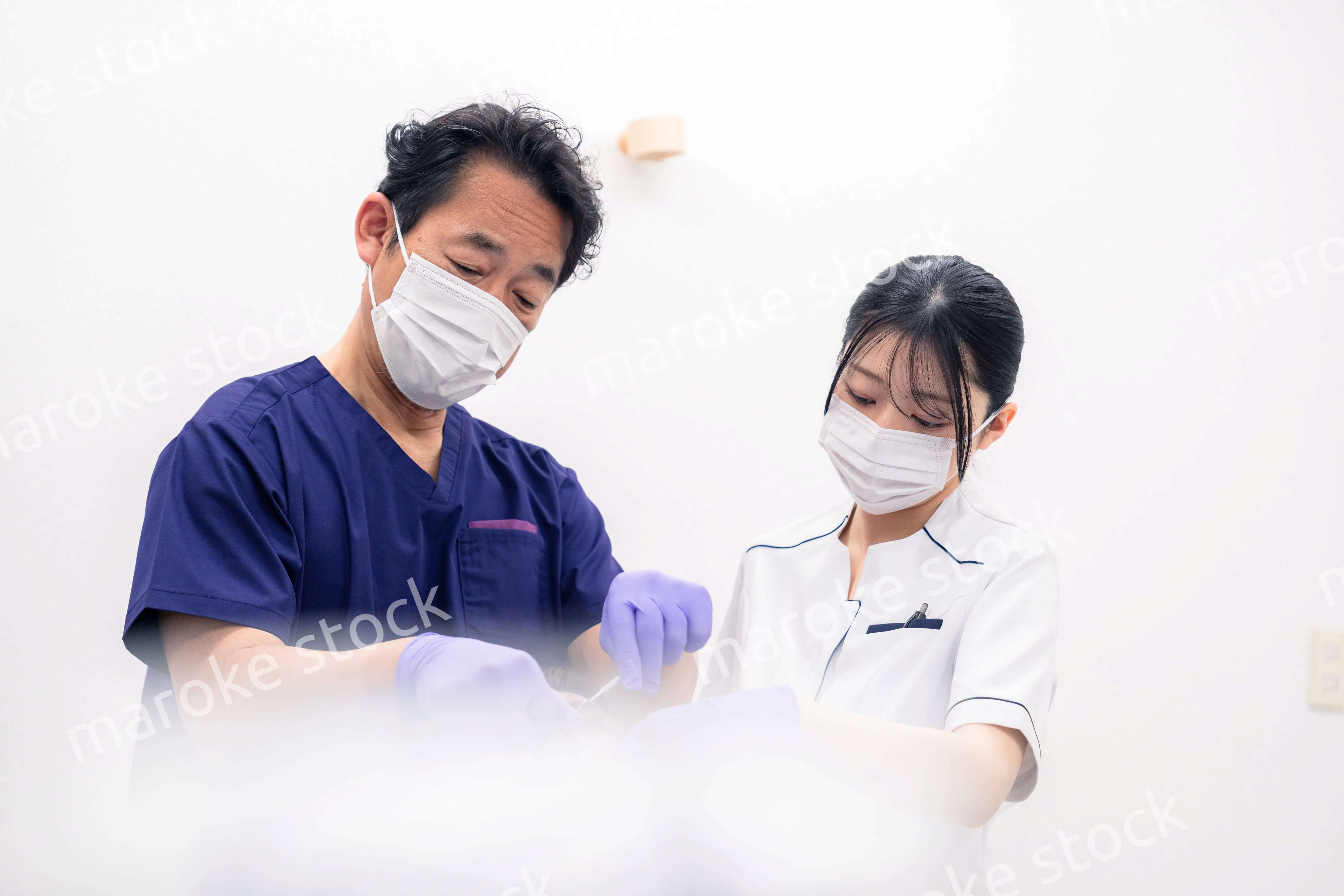 歯科治療をする歯科医師と歯科助手