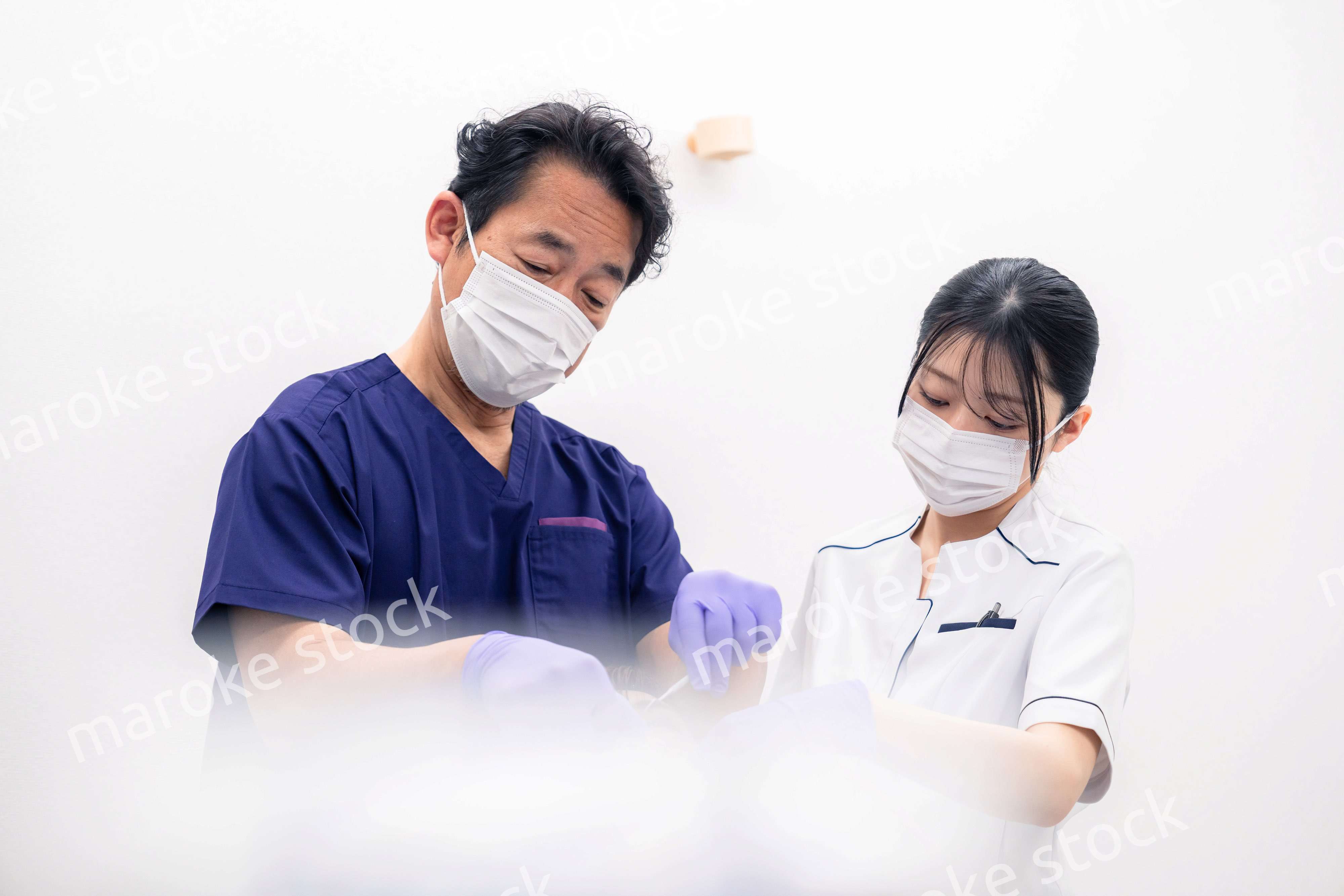 歯科治療をする歯科医師と歯科助手