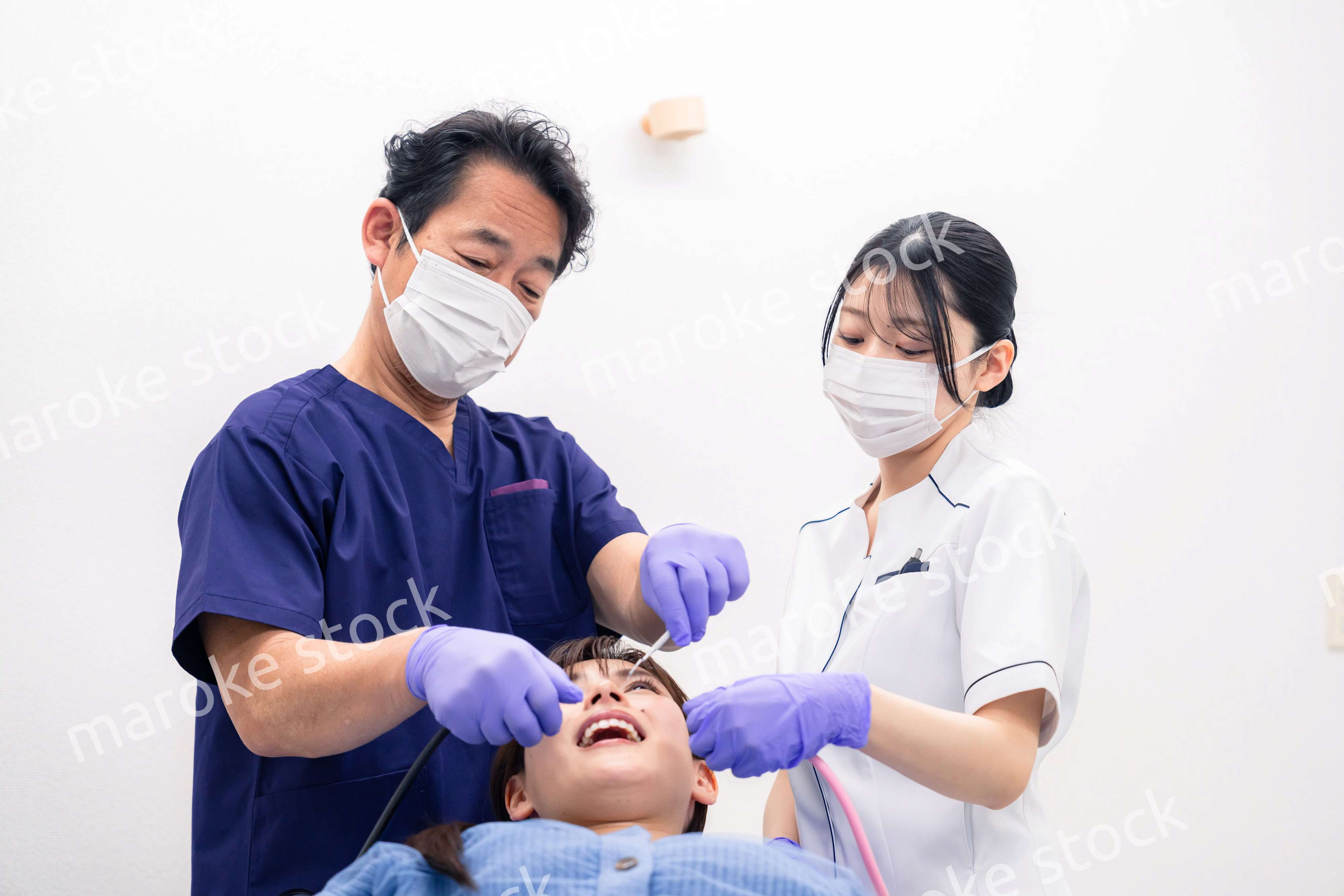 歯科治療をする歯科医師と歯科助手