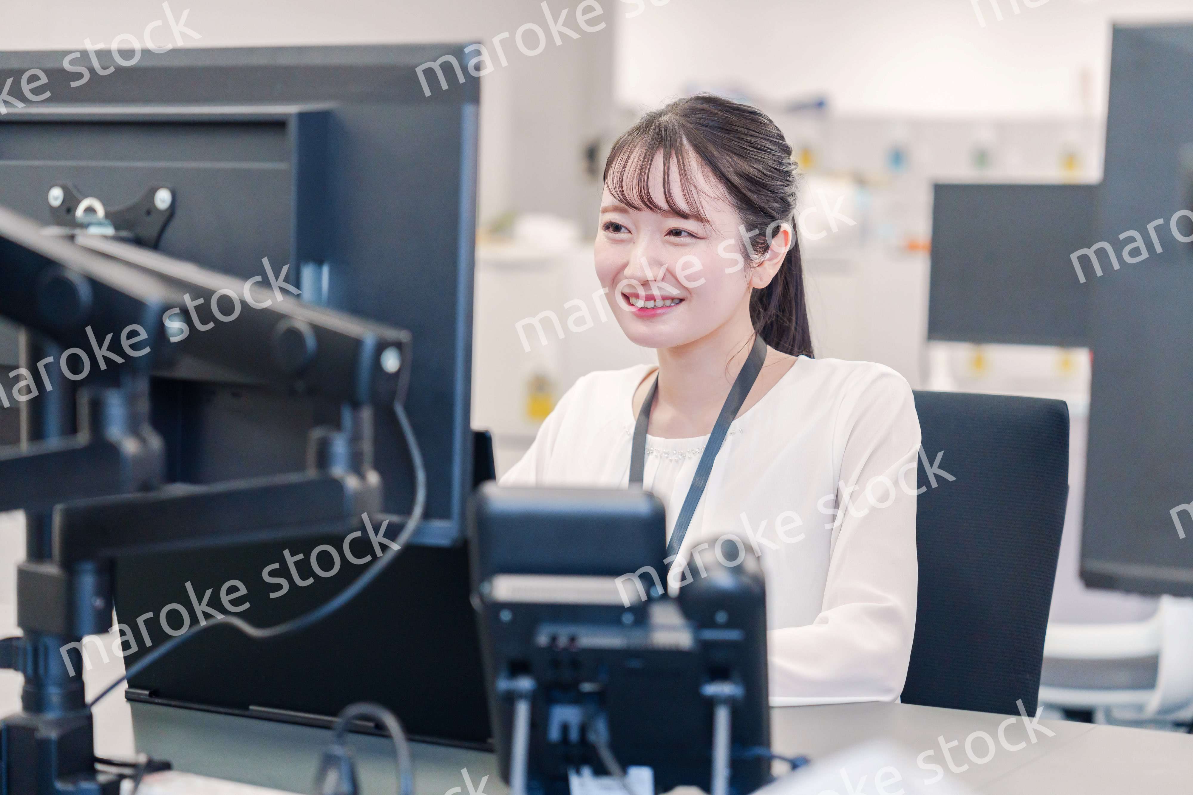 オフィスで楽しく働く若いキャリアウーマン