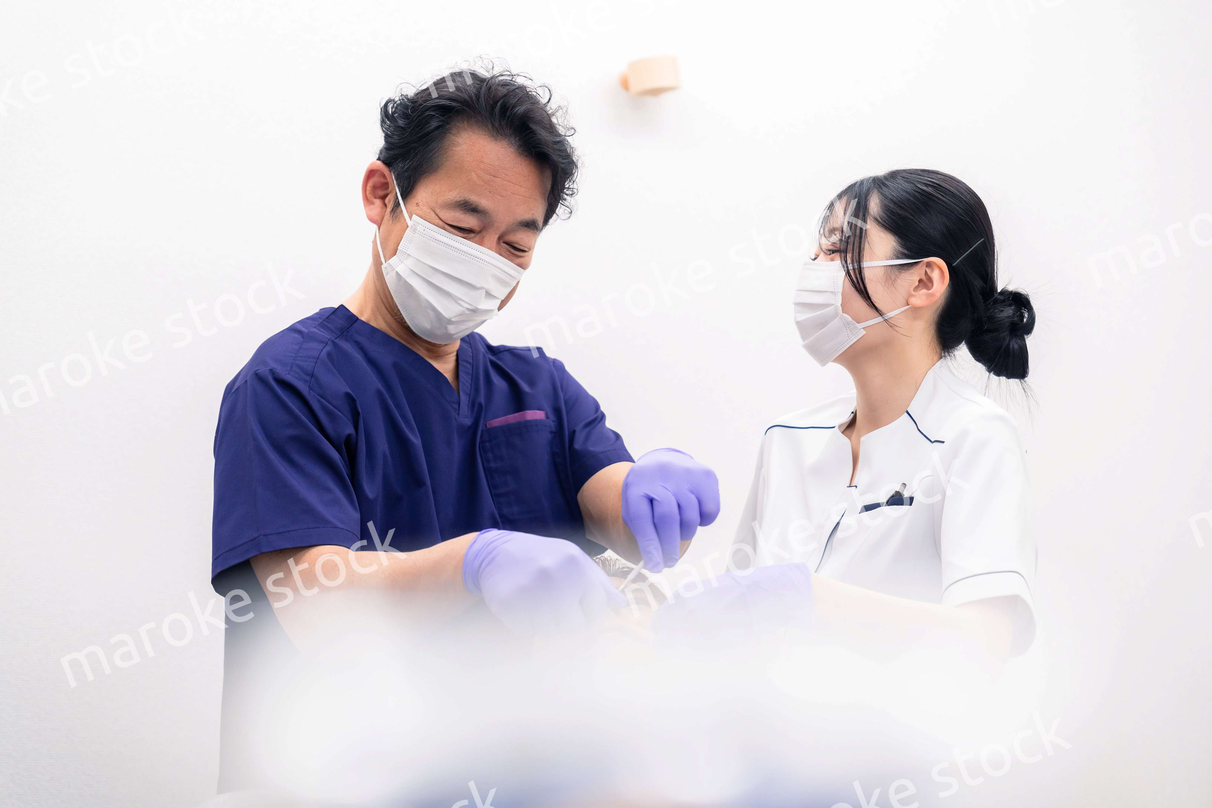 歯科治療をする歯科医師と歯科助手