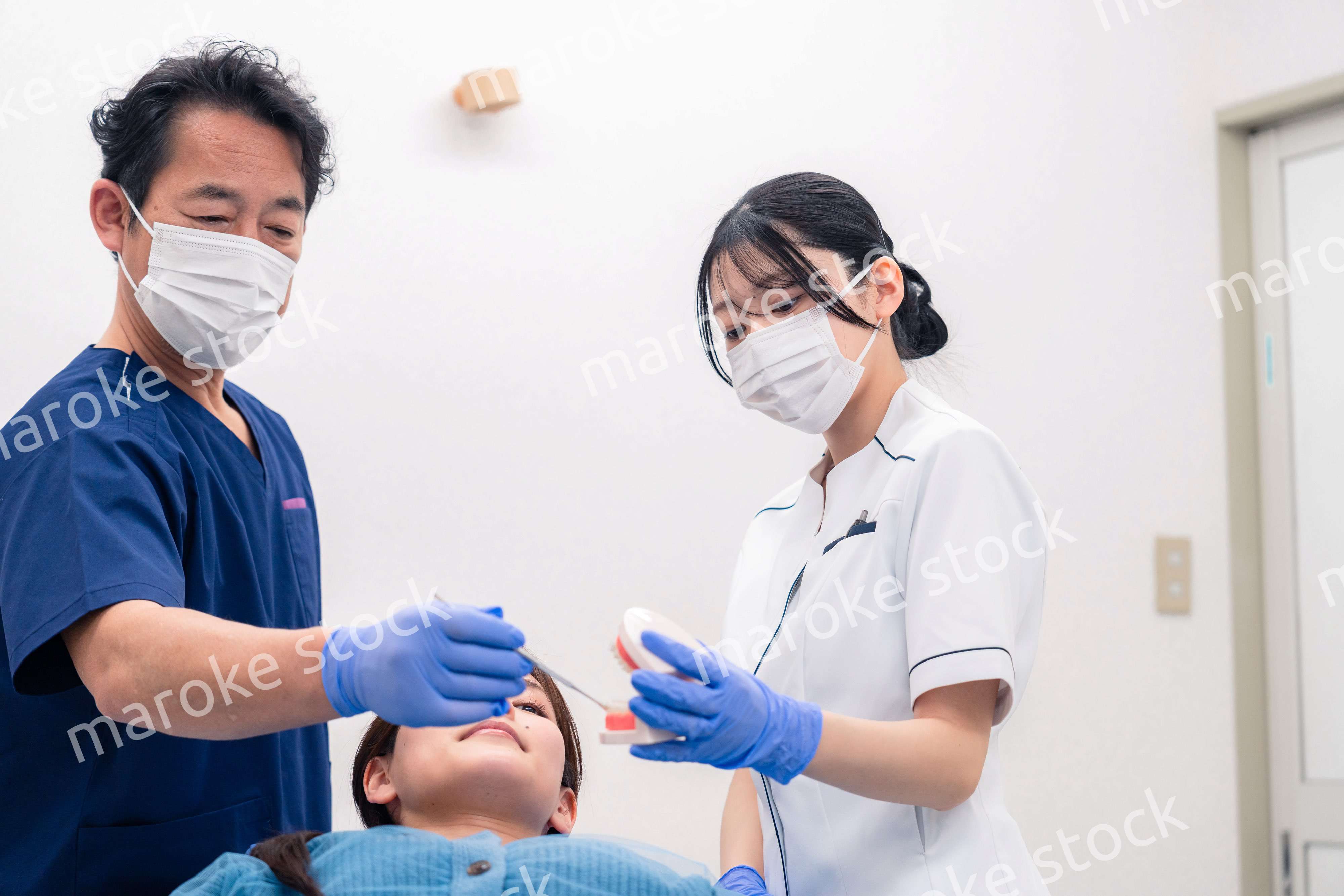 模型を使って患者に治療方針を説明する歯医者さん