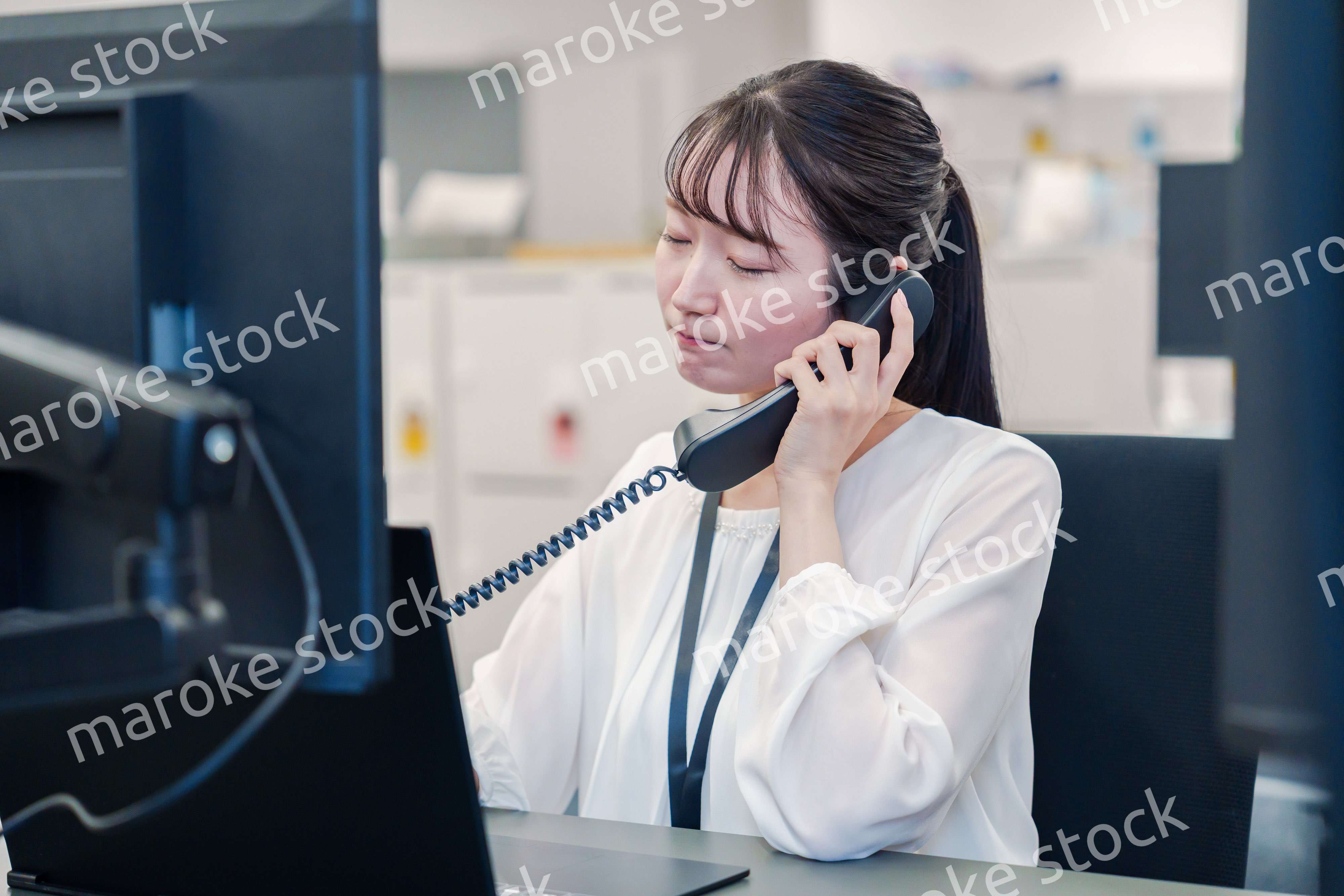 お客様からの電話に困惑をする若い女性オペレーター