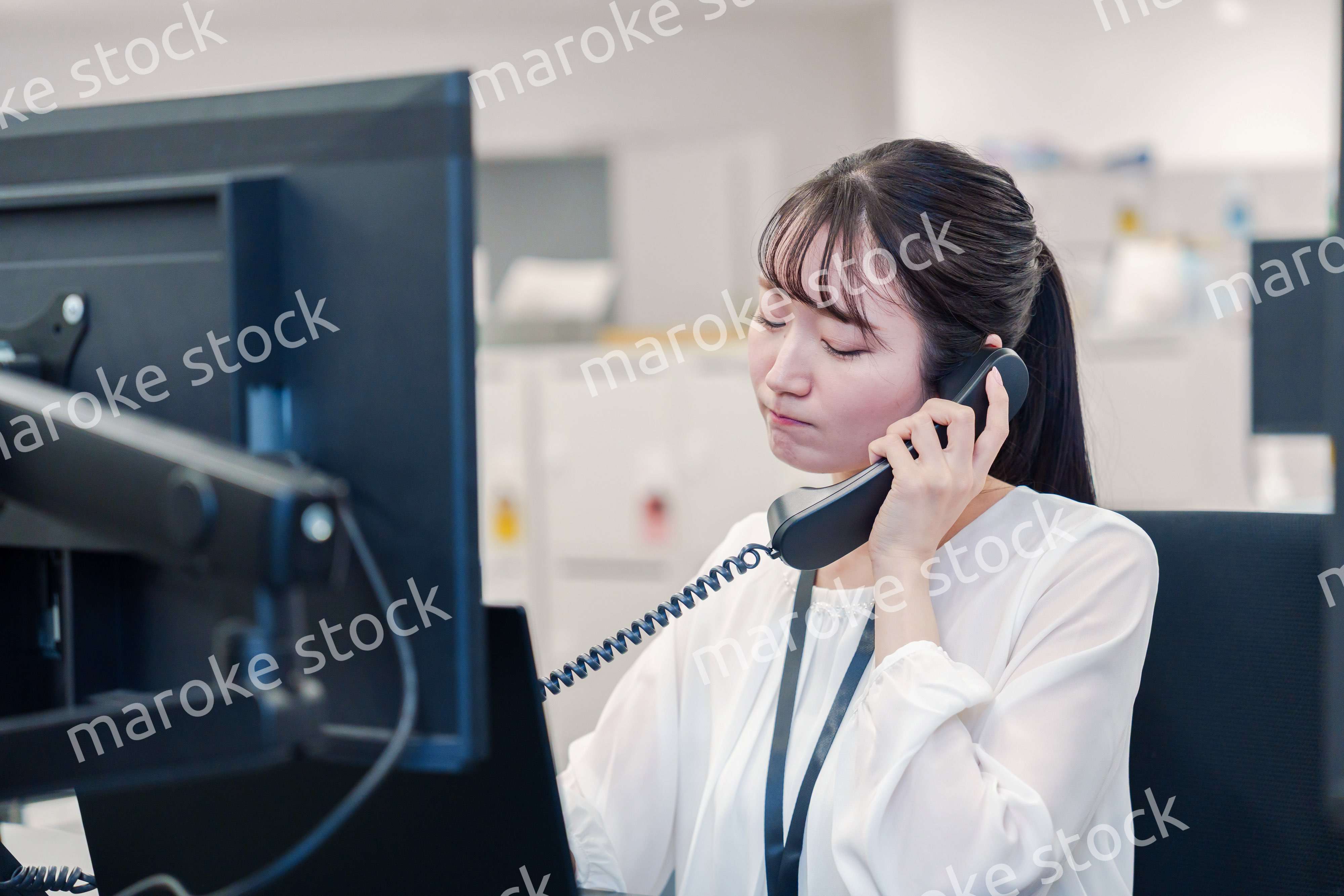 お客様からの電話に困惑をする若い女性オペレーター