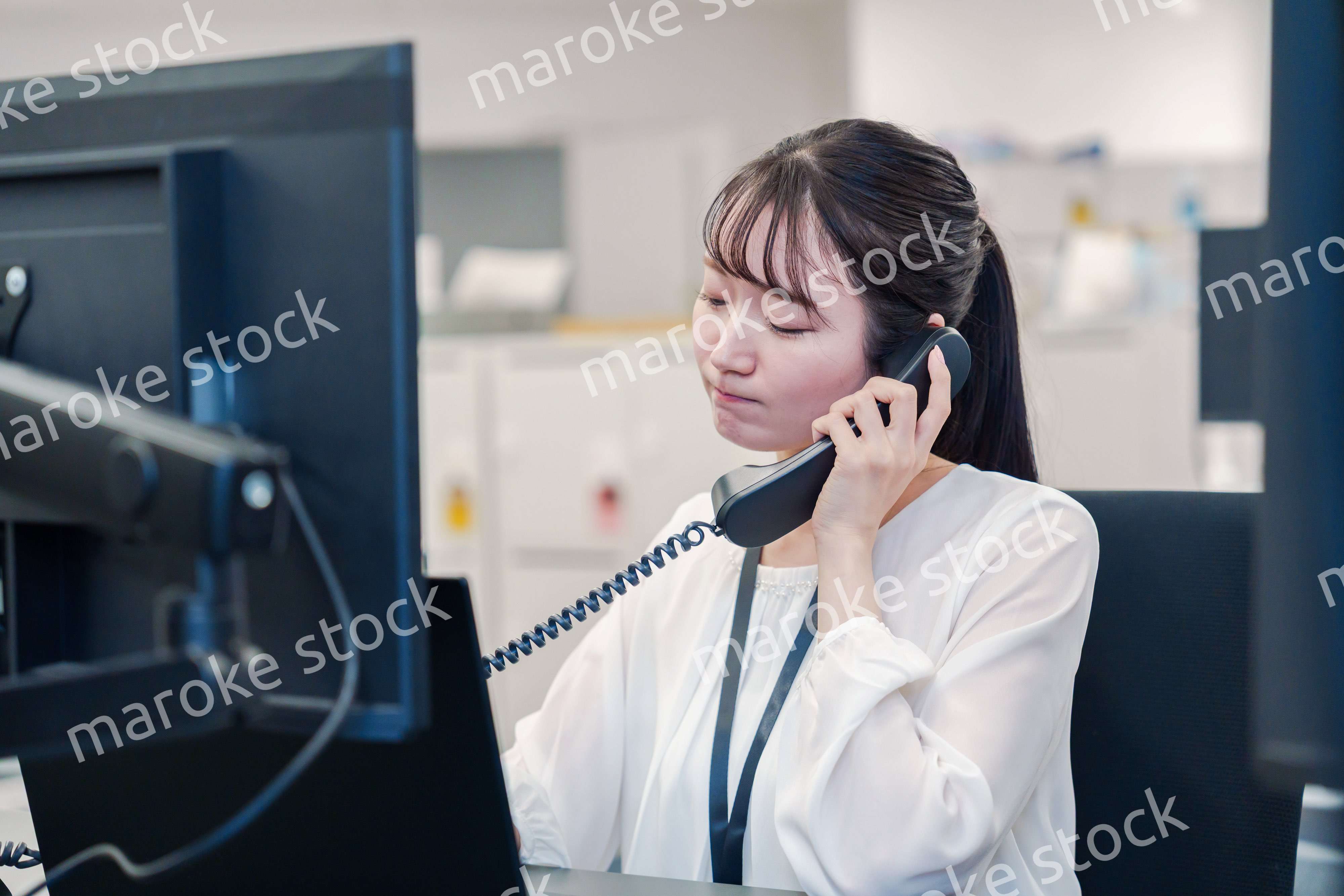 お客様からの電話に困惑をする若い女性オペレーター