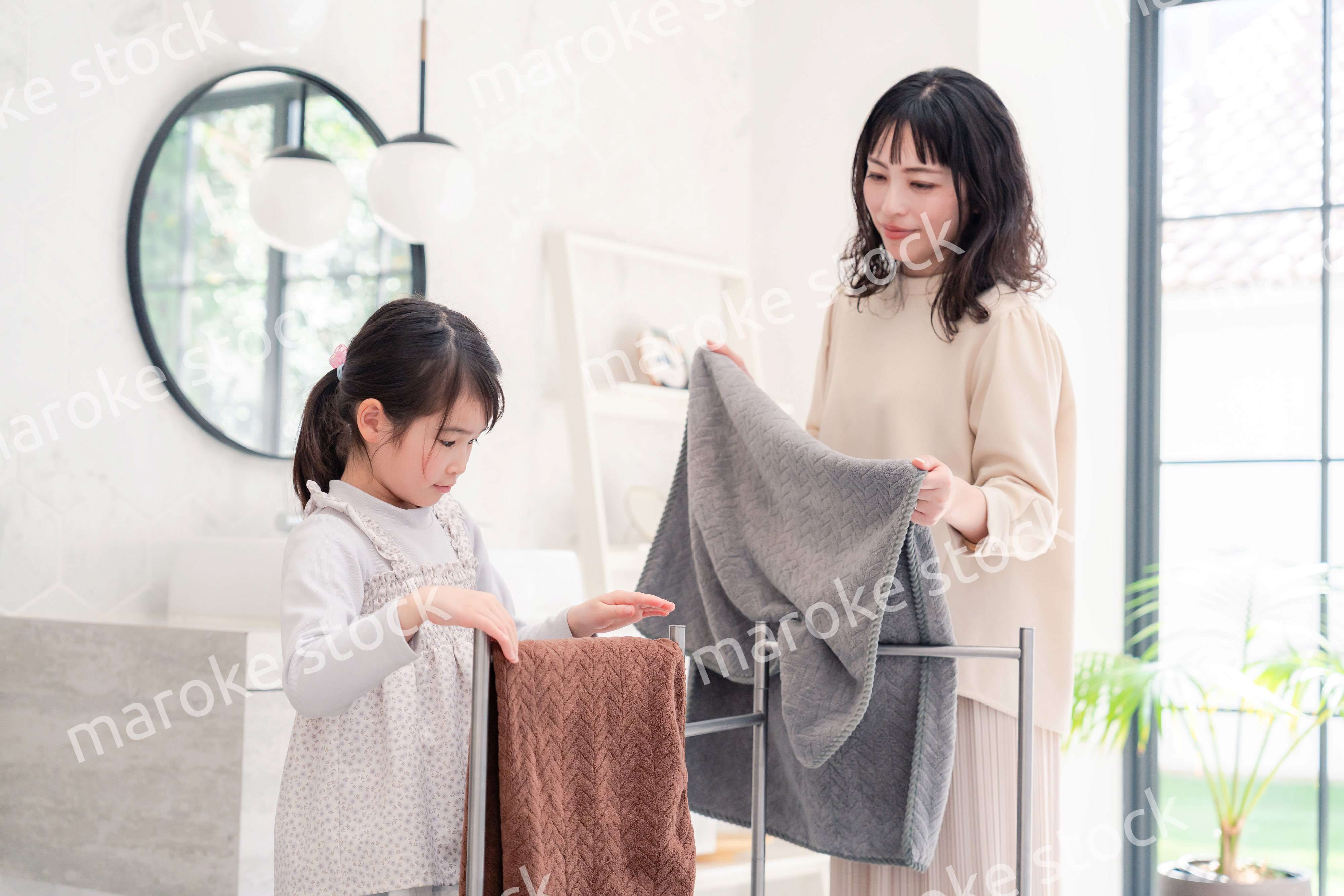 洗濯物干しをお手伝いする小さな女の子