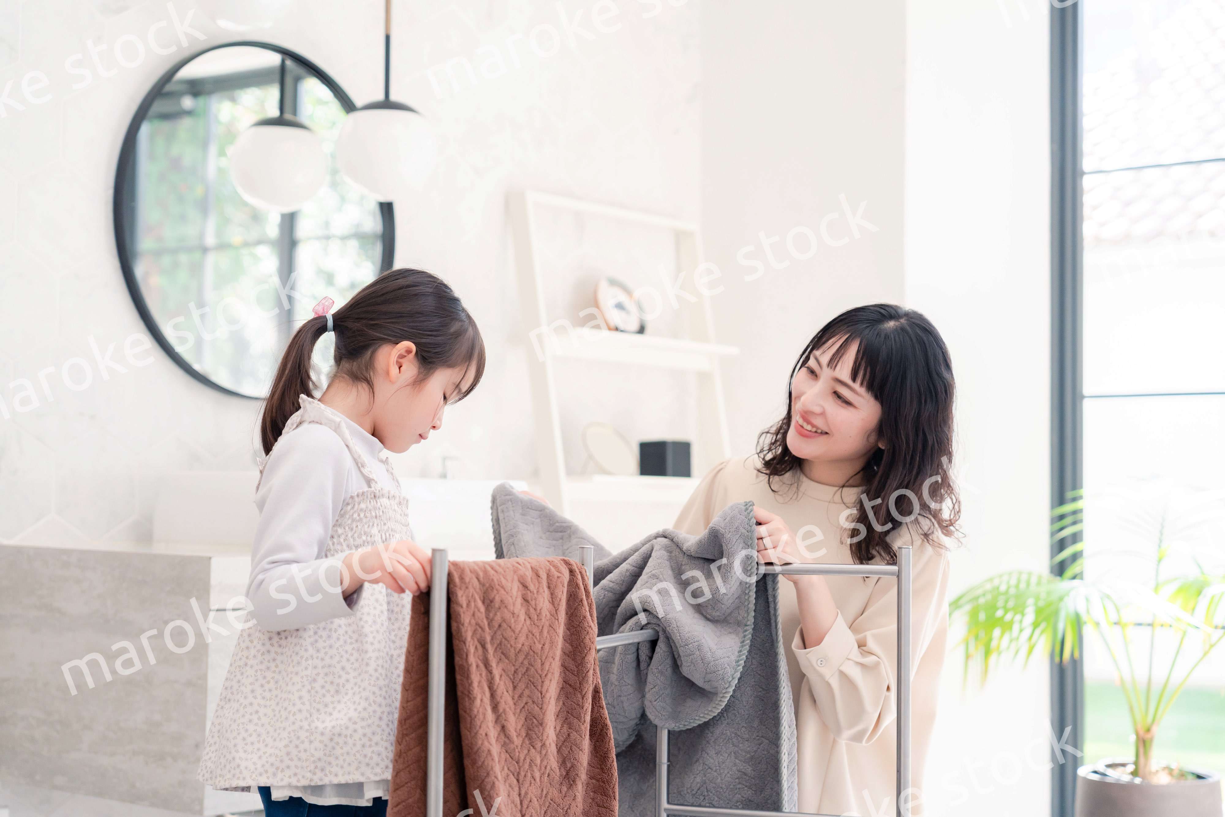 洗濯物干しをお手伝いする小さな女の子