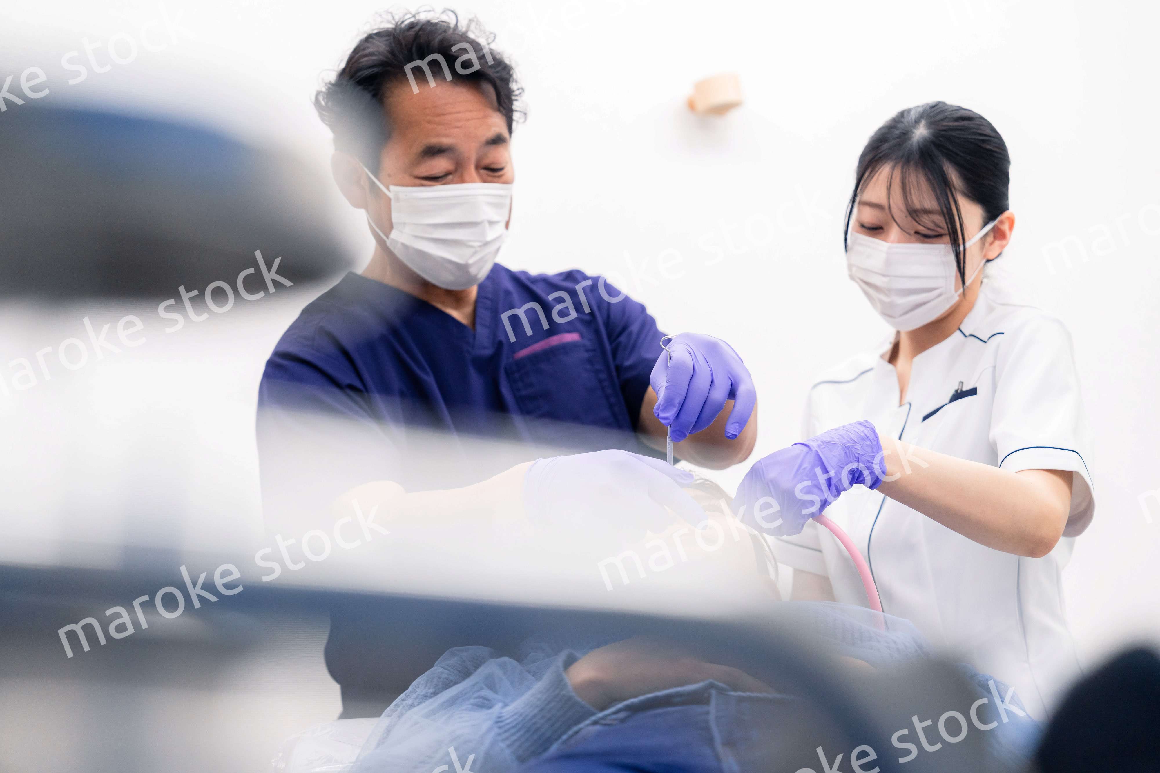 歯科治療をする歯科医師と歯科助手