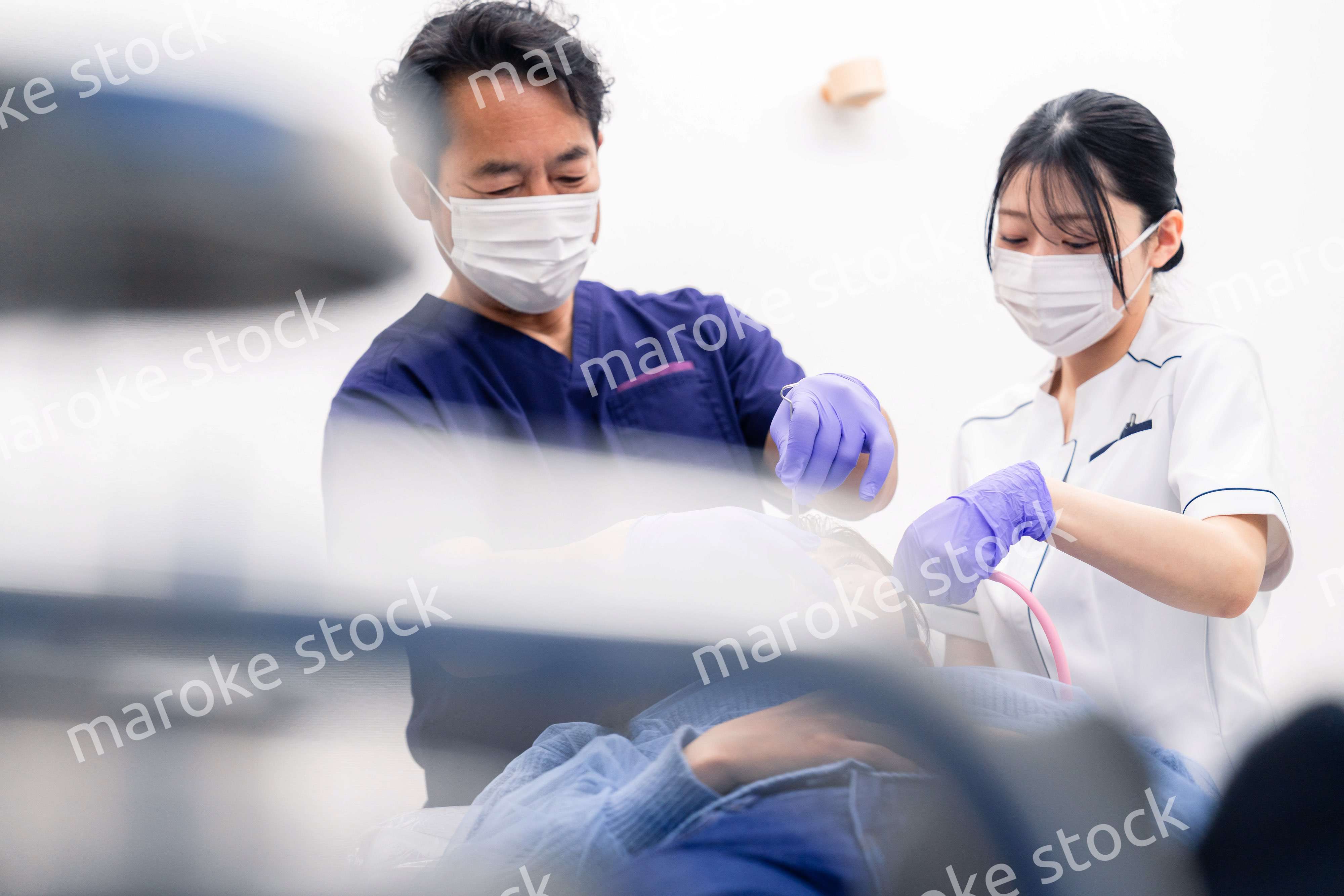 歯科治療をする歯科医師と歯科助手