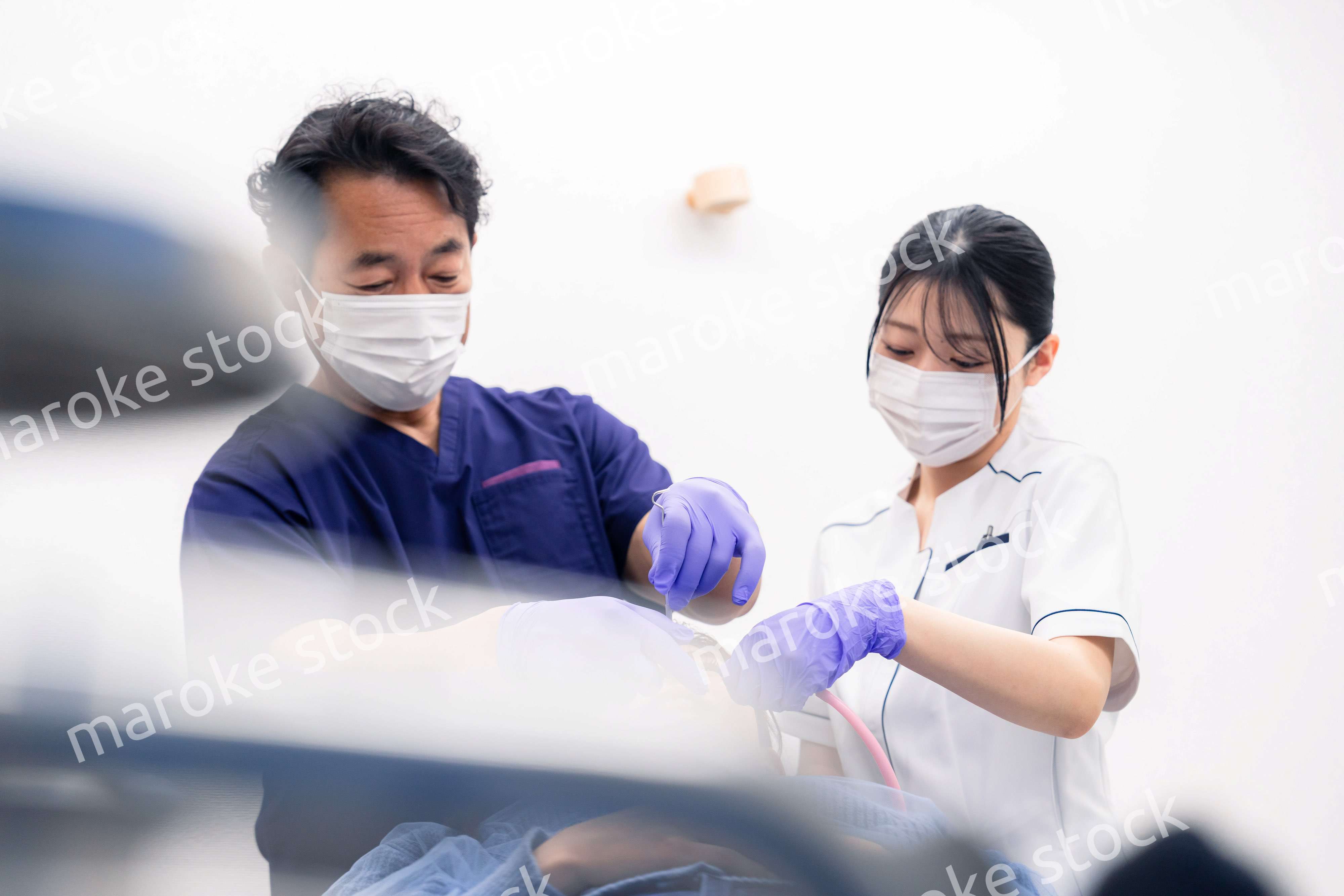 歯科治療をする歯科医師と歯科助手