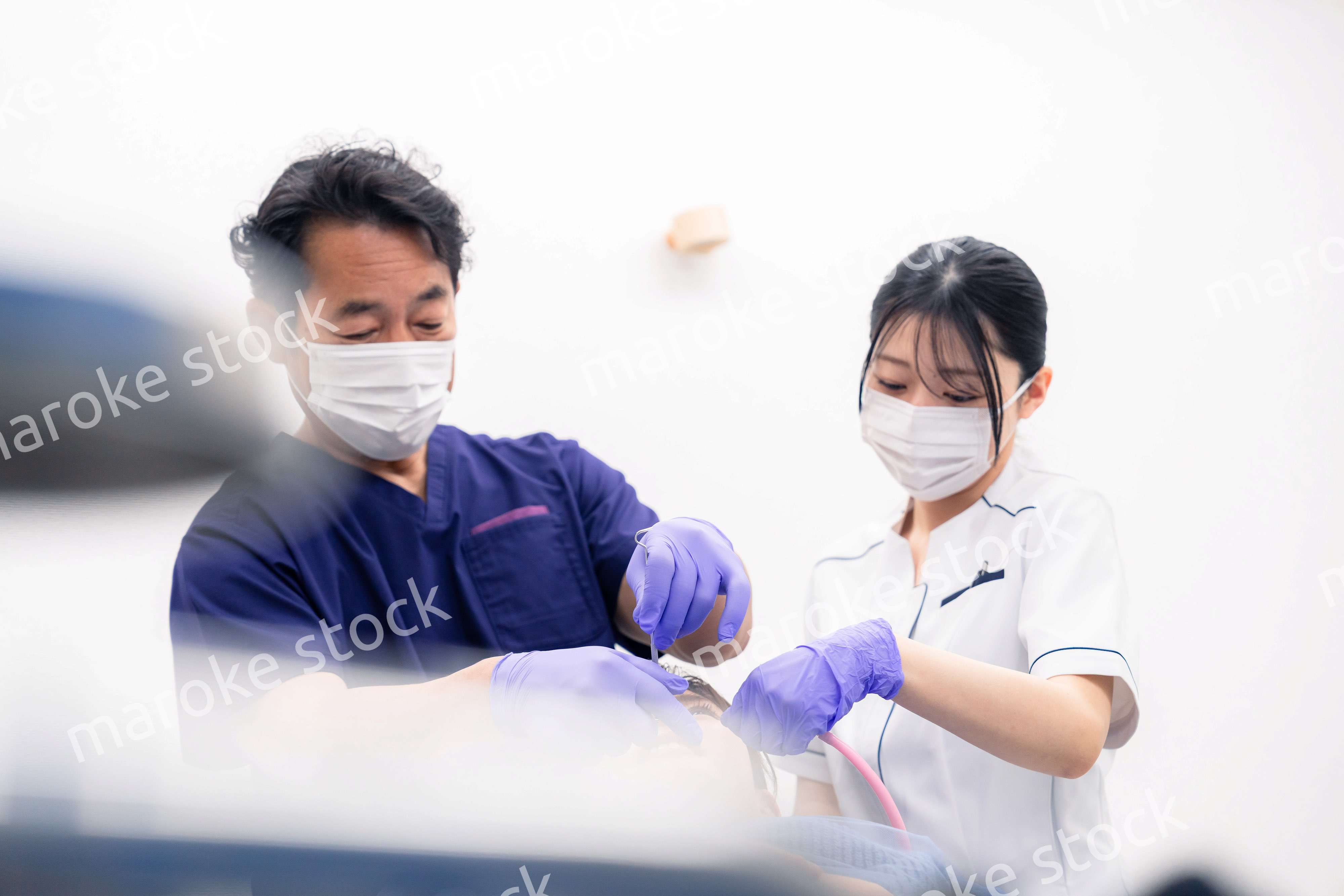 歯科治療をする歯科医師と歯科助手