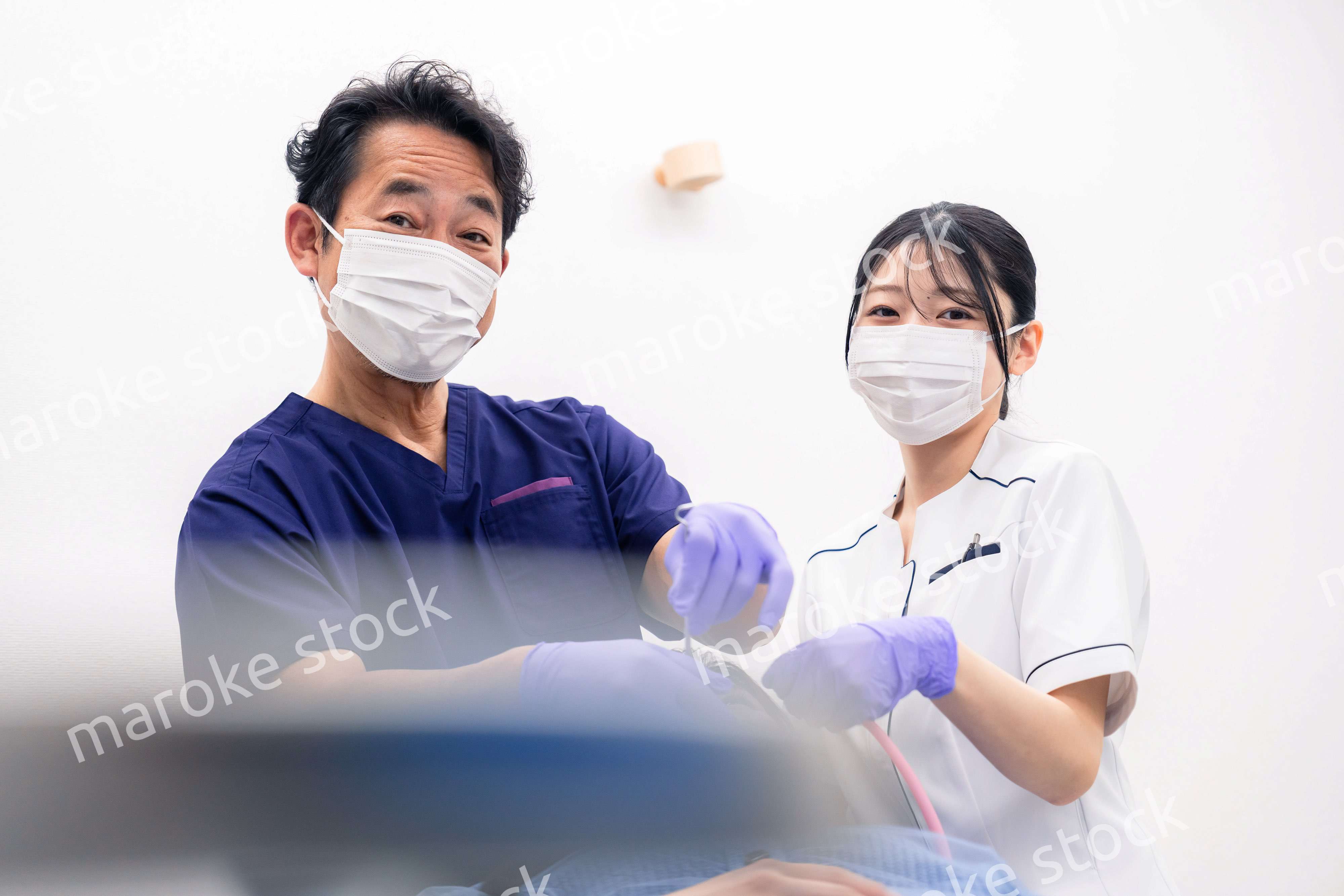 歯科治療をする歯科医師と歯科助手