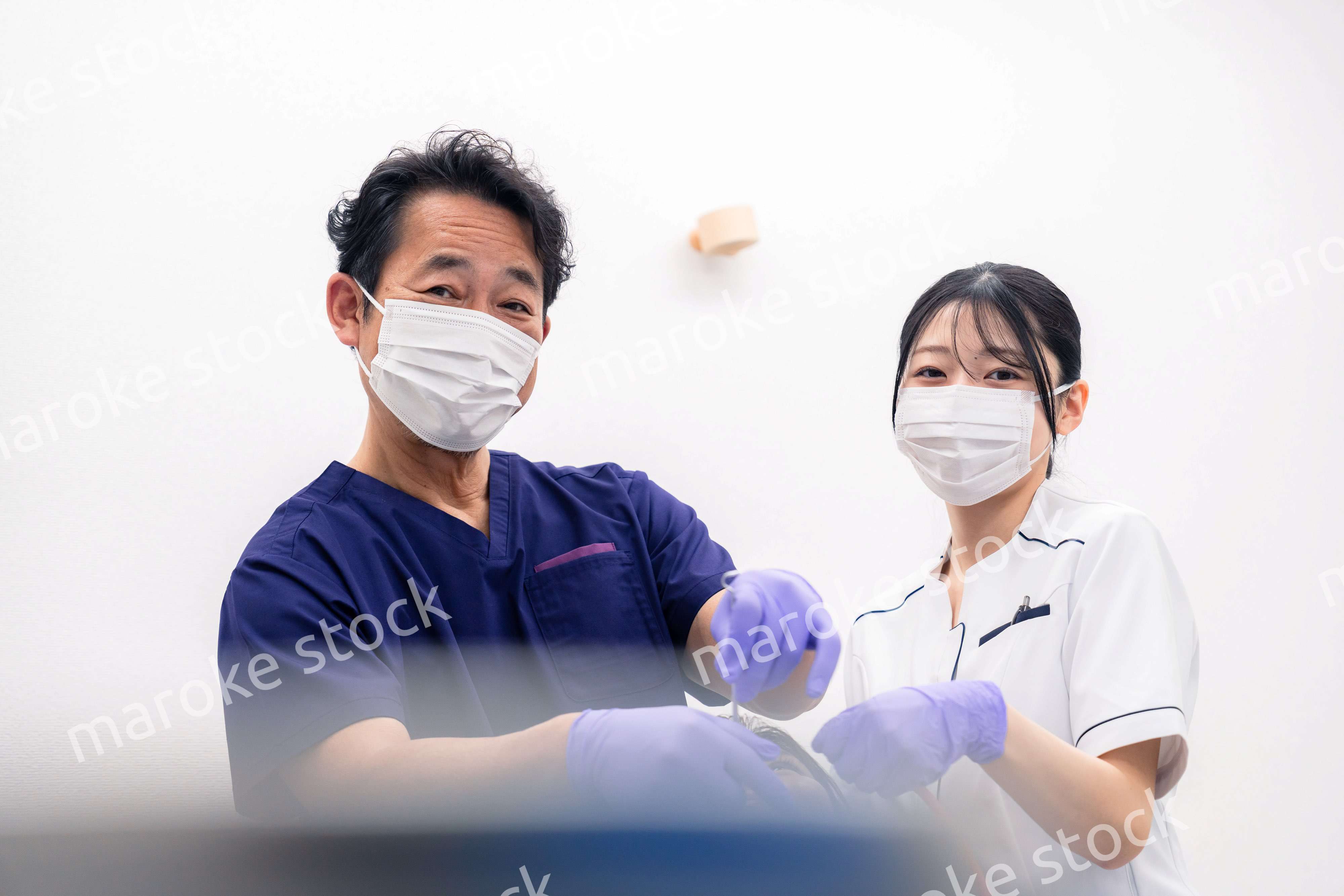 歯科治療をする歯科医師と歯科助手