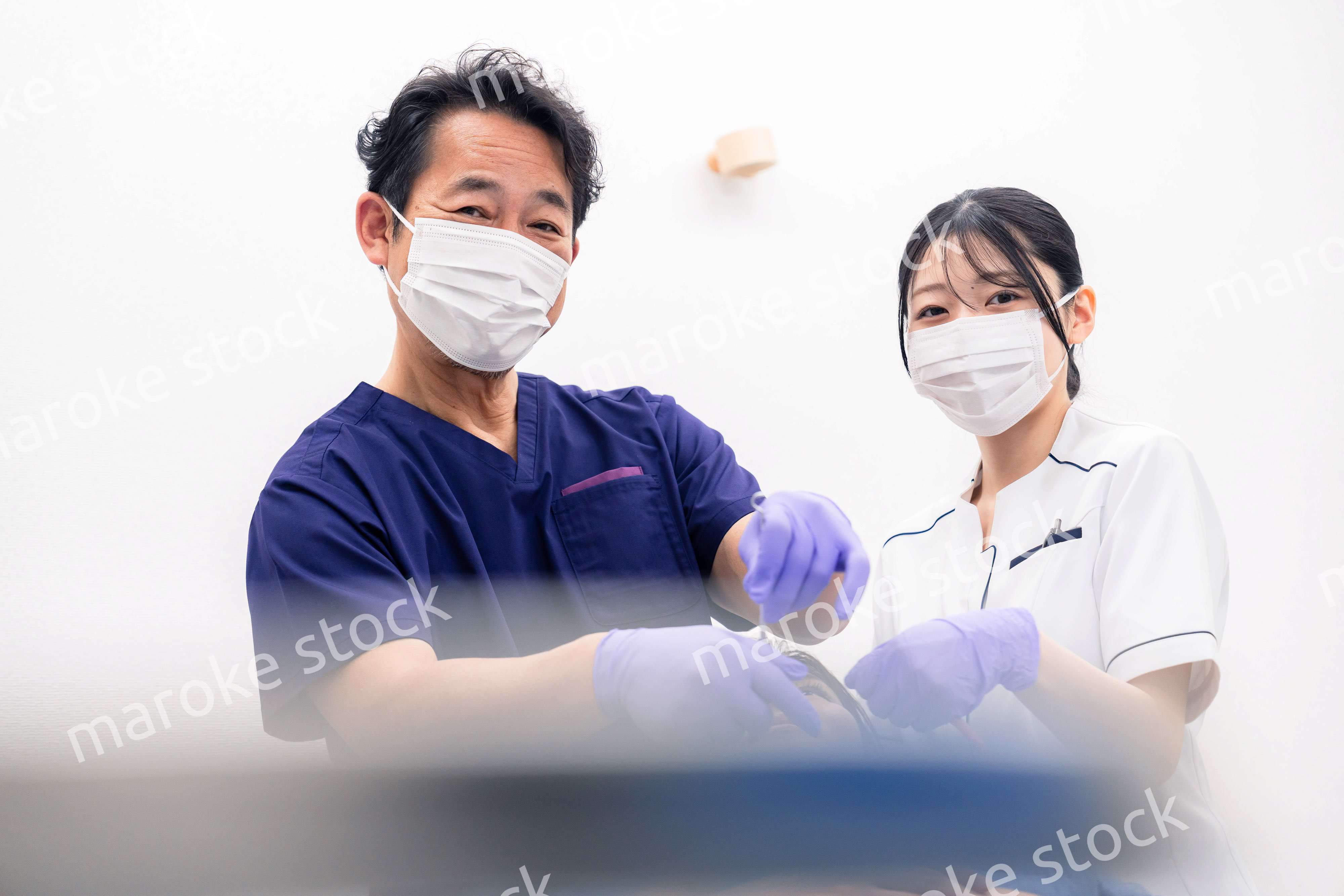 歯科治療をする歯科医師と歯科助手