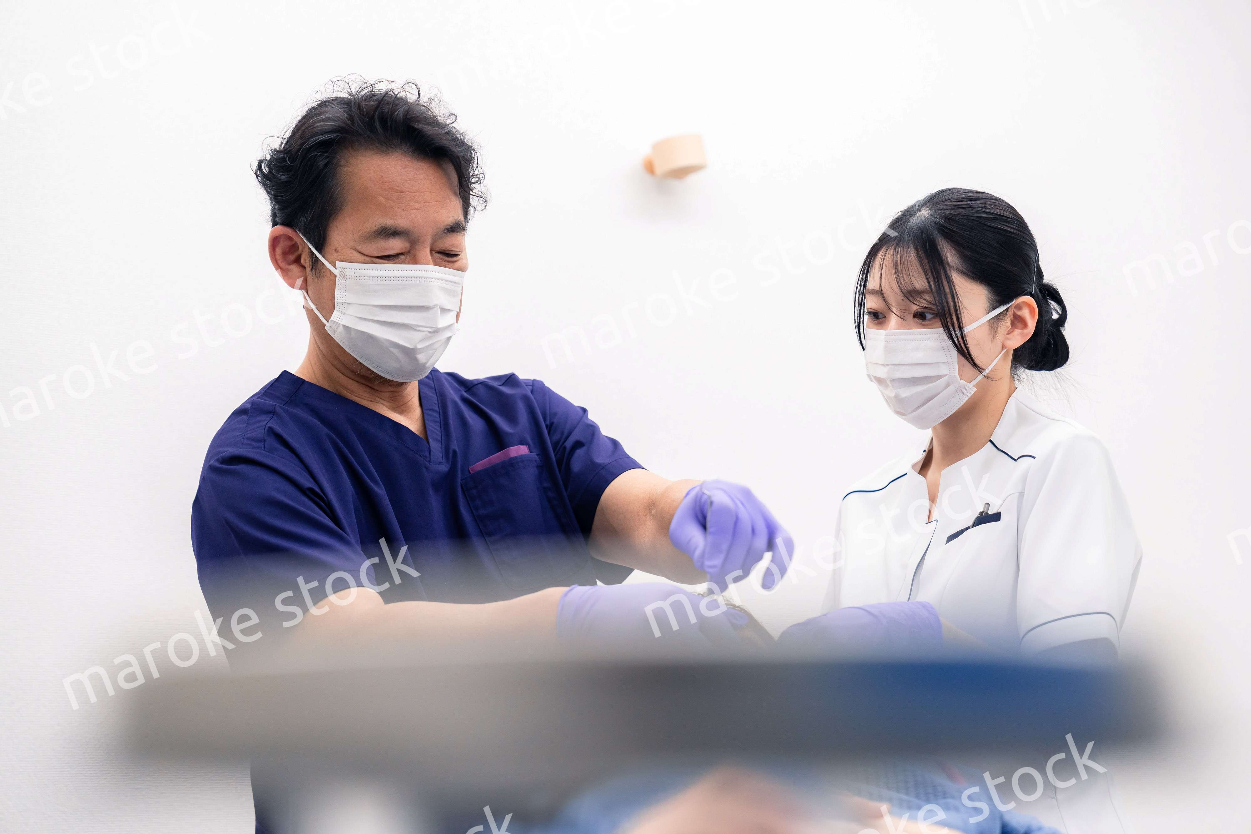 歯科治療をする歯科医師と歯科助手