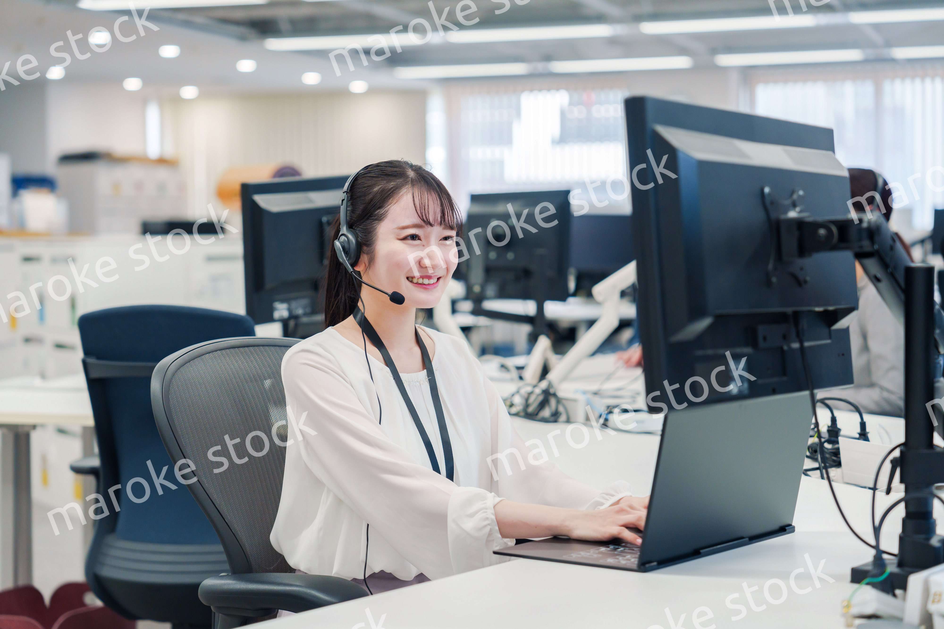 コールセンターでお客さま対応をするオペレーターの女性