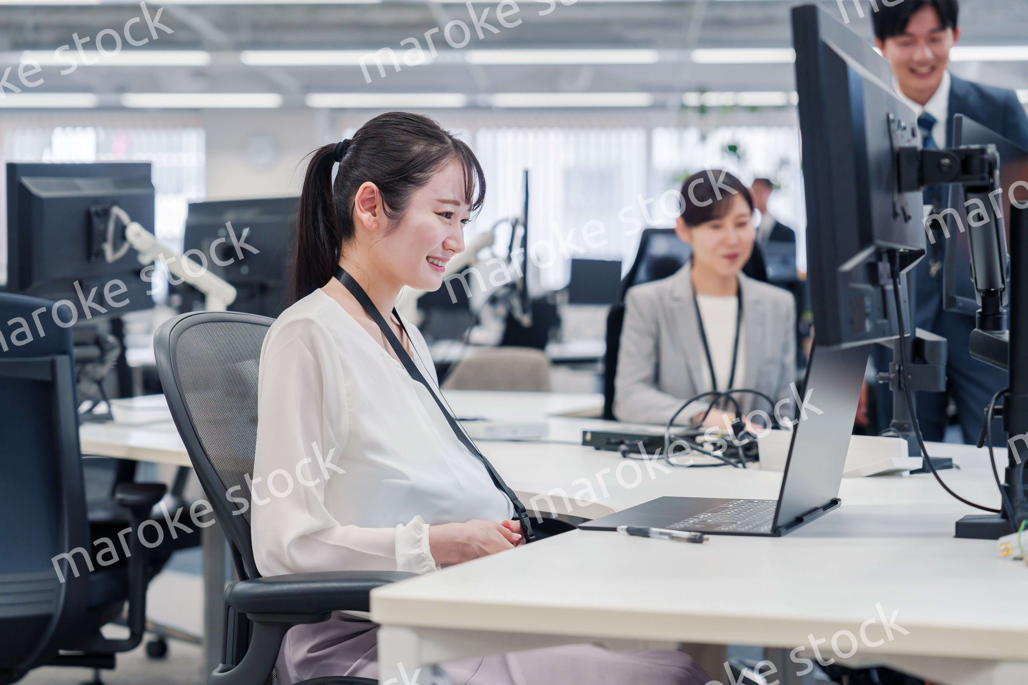 オフィスでデスクワークをする妊婦の女性