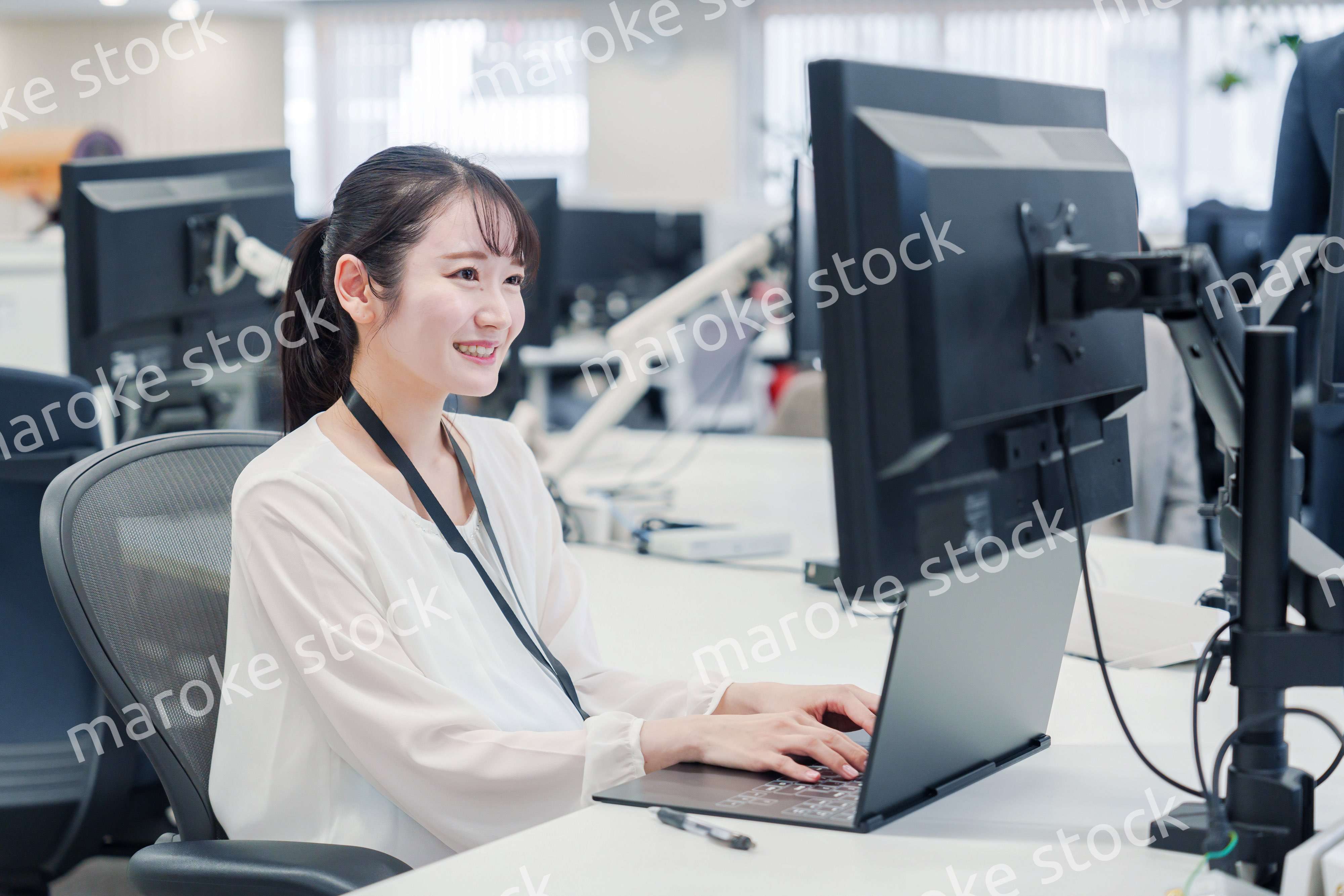 オフィスでデスクワークをする妊婦の女性