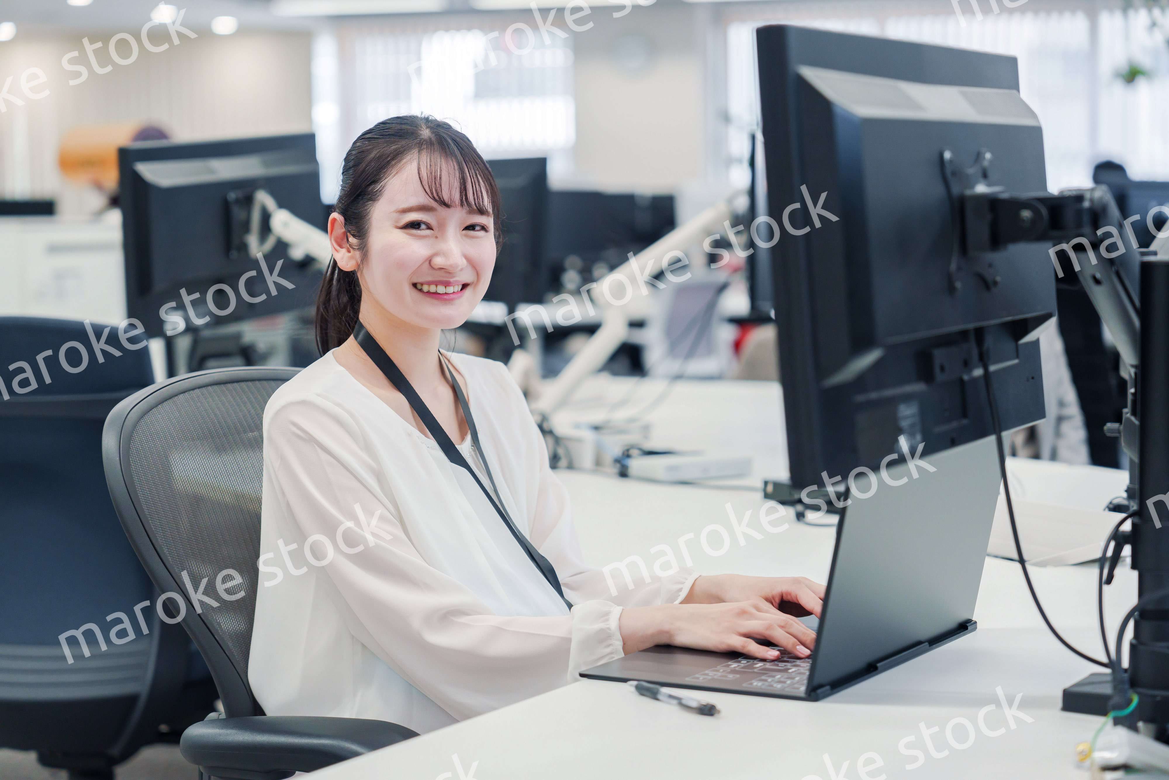 オフィスでデスクワークをする妊婦の女性