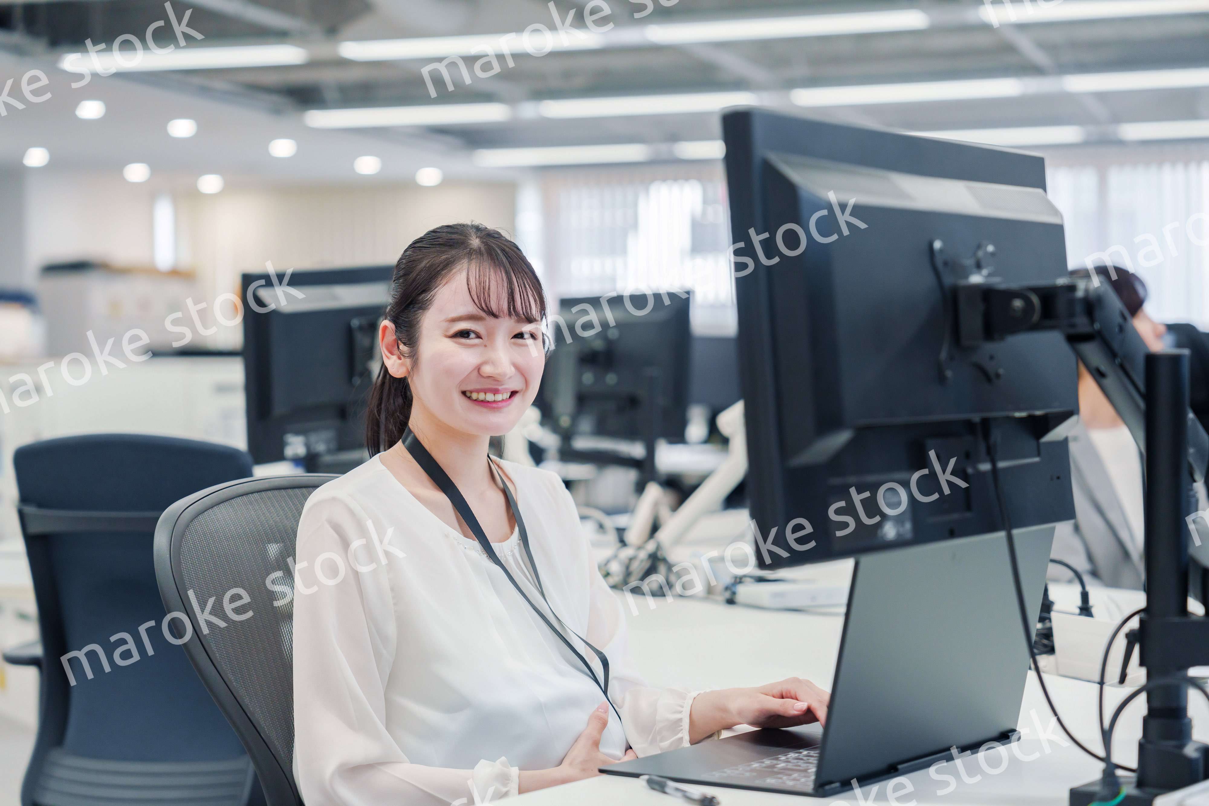 オフィスでデスクワークをする妊婦の女性