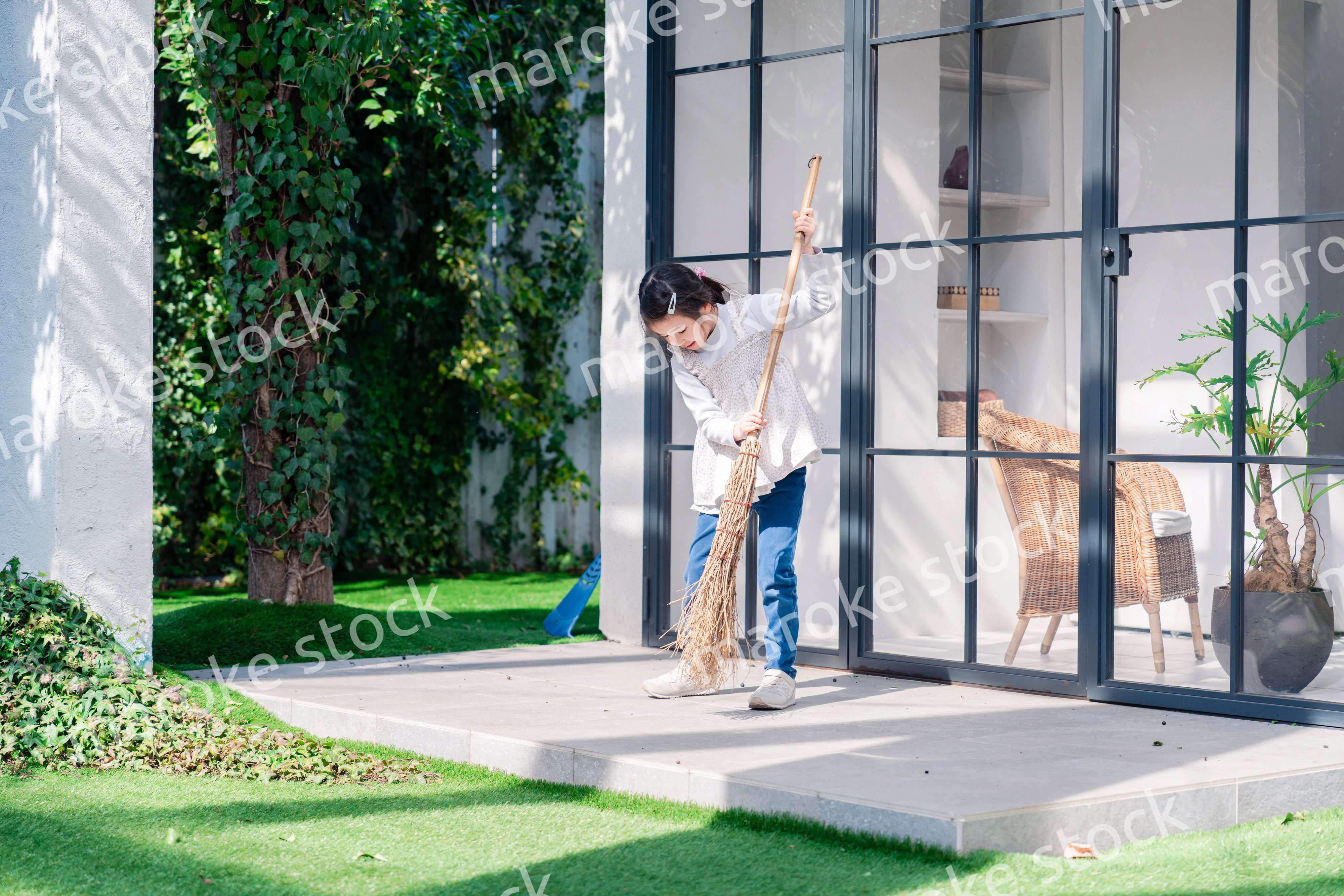家の外の掃除を手伝う女の子