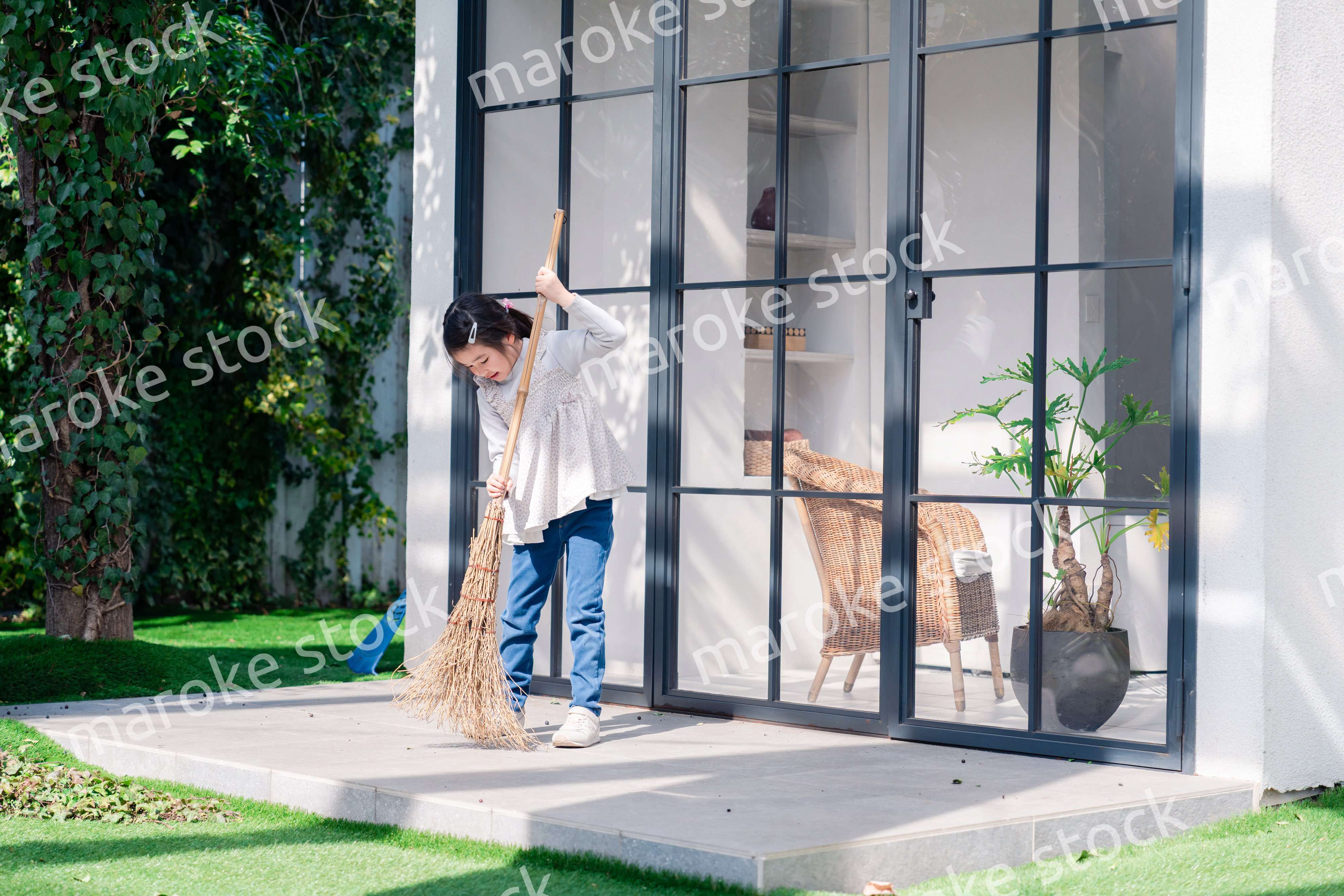 家の外の掃除を手伝う女の子