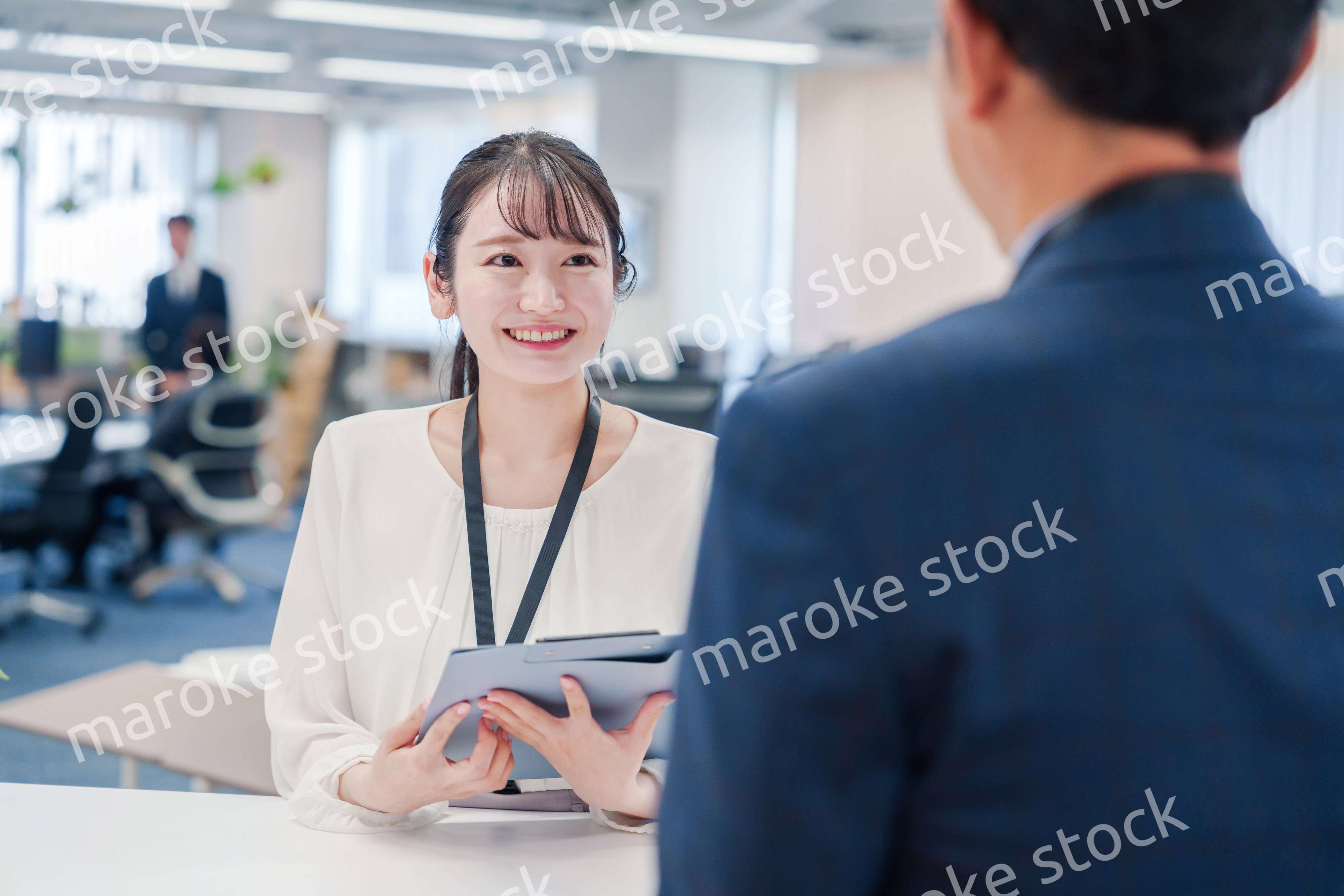 窓口で来客の対応をする女性スタッフ