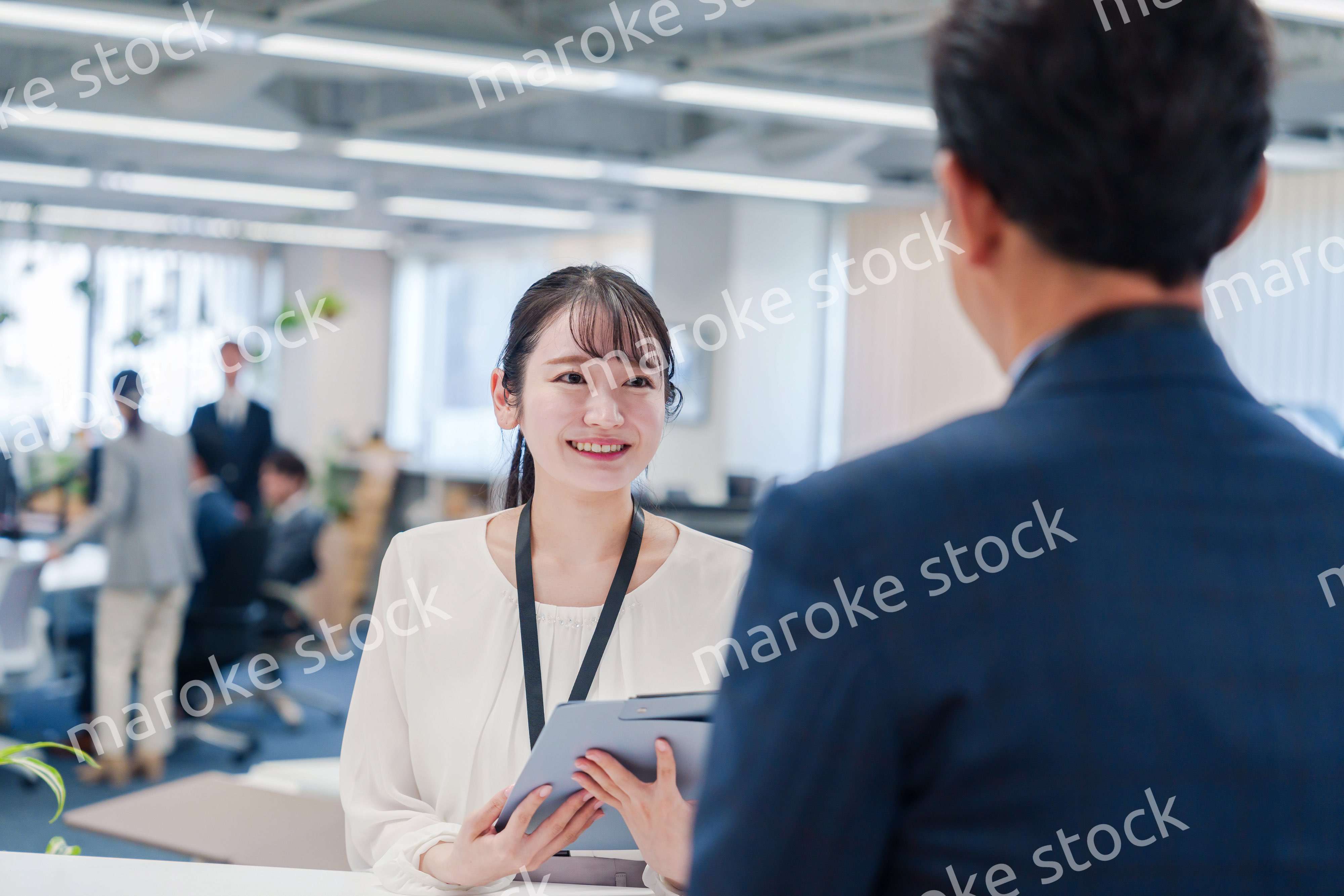 窓口で来客の対応をする女性スタッフ