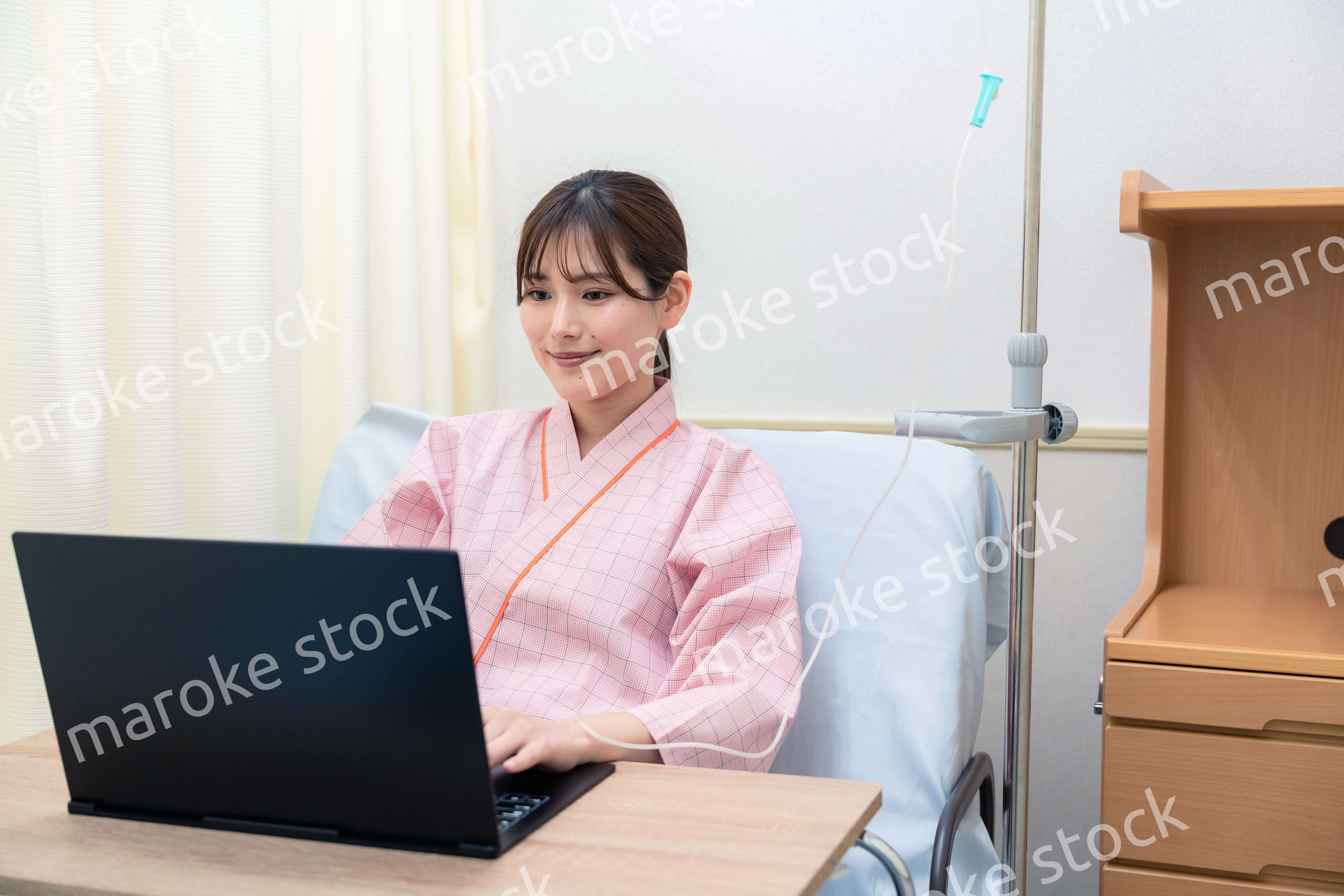 病室でパソコンを使う入院患者