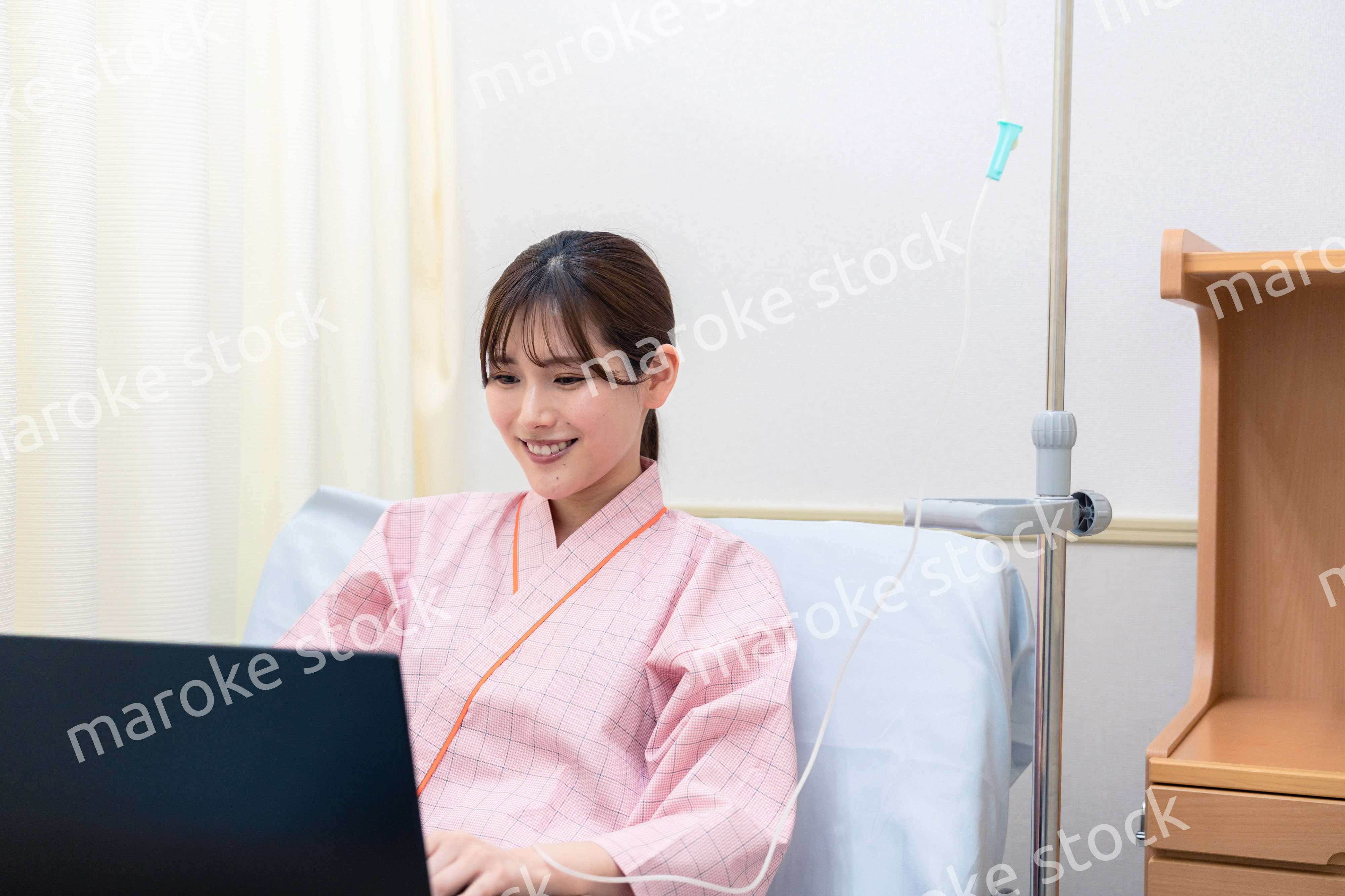 病室でパソコンを使う入院患者