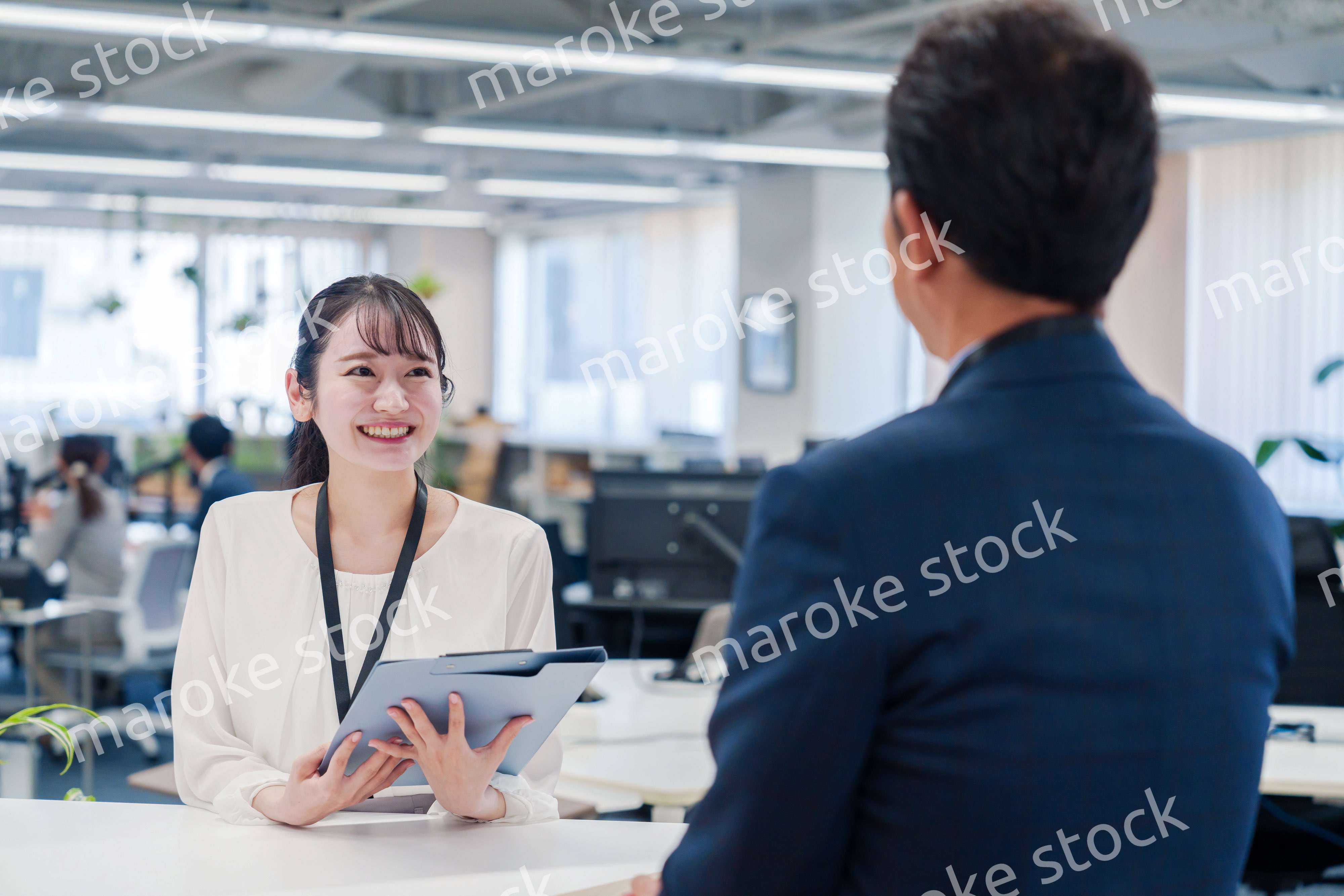 窓口で来客の対応をする女性スタッフ