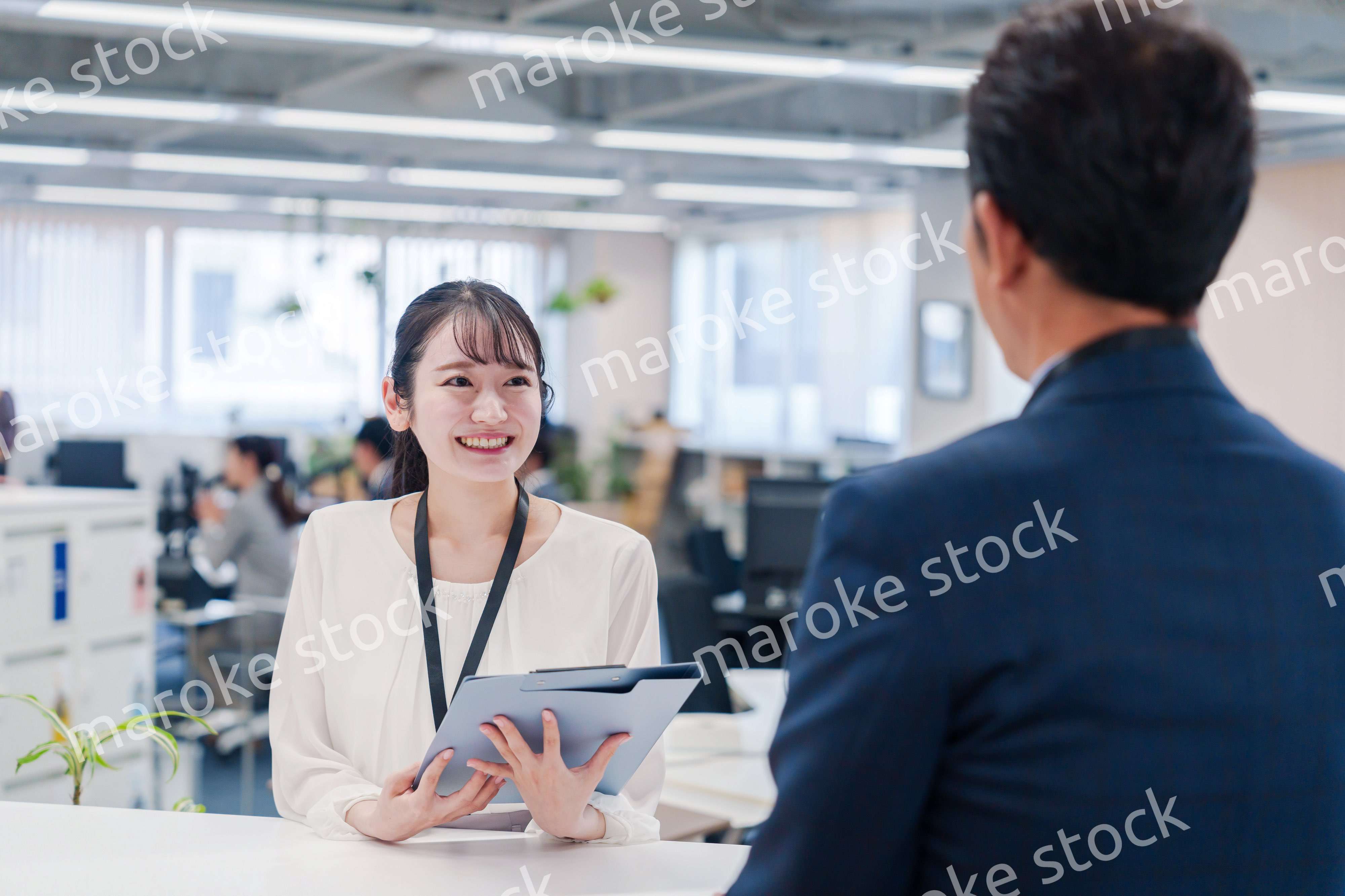 窓口で来客の対応をする女性スタッフ