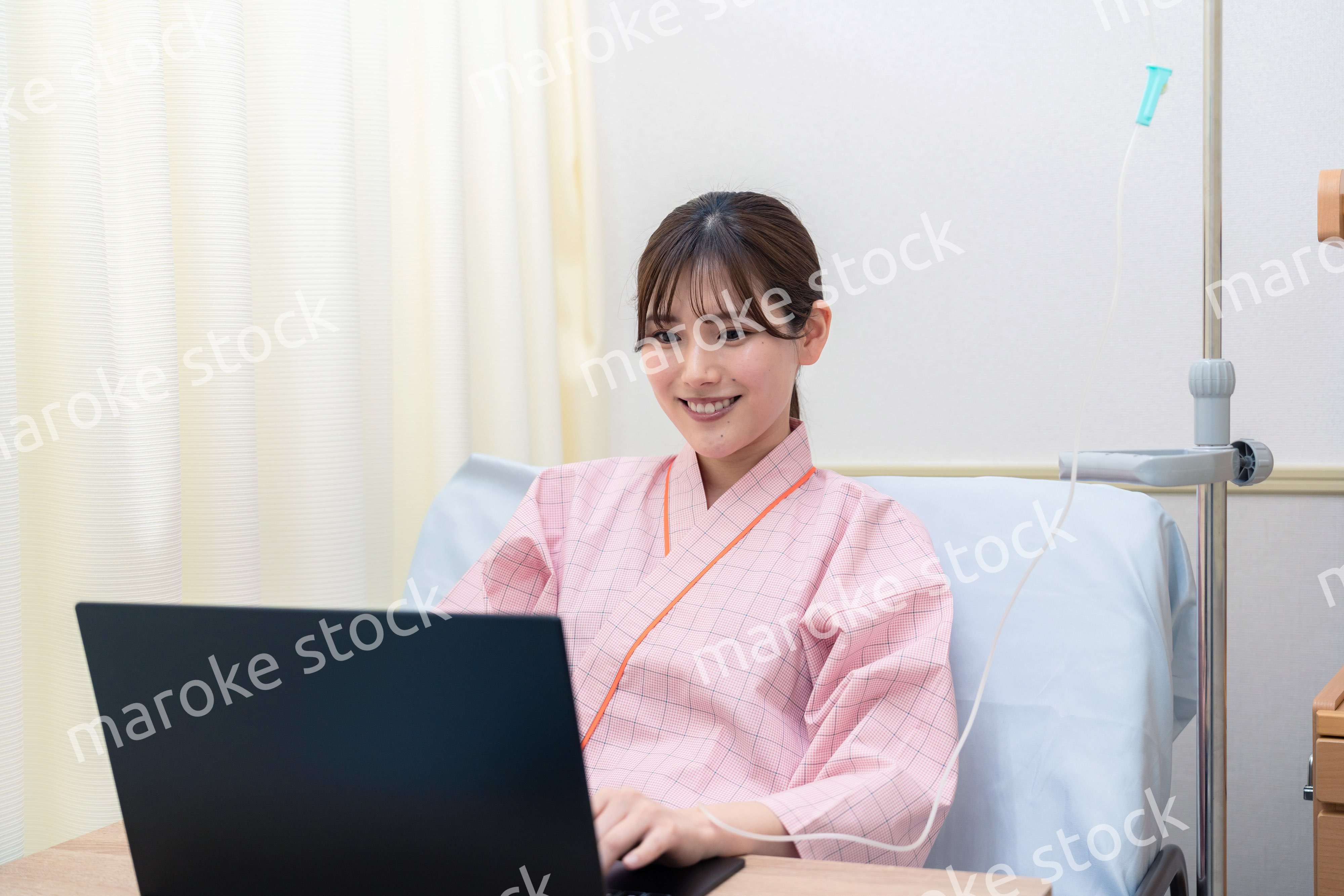 病室でパソコンを使う入院患者