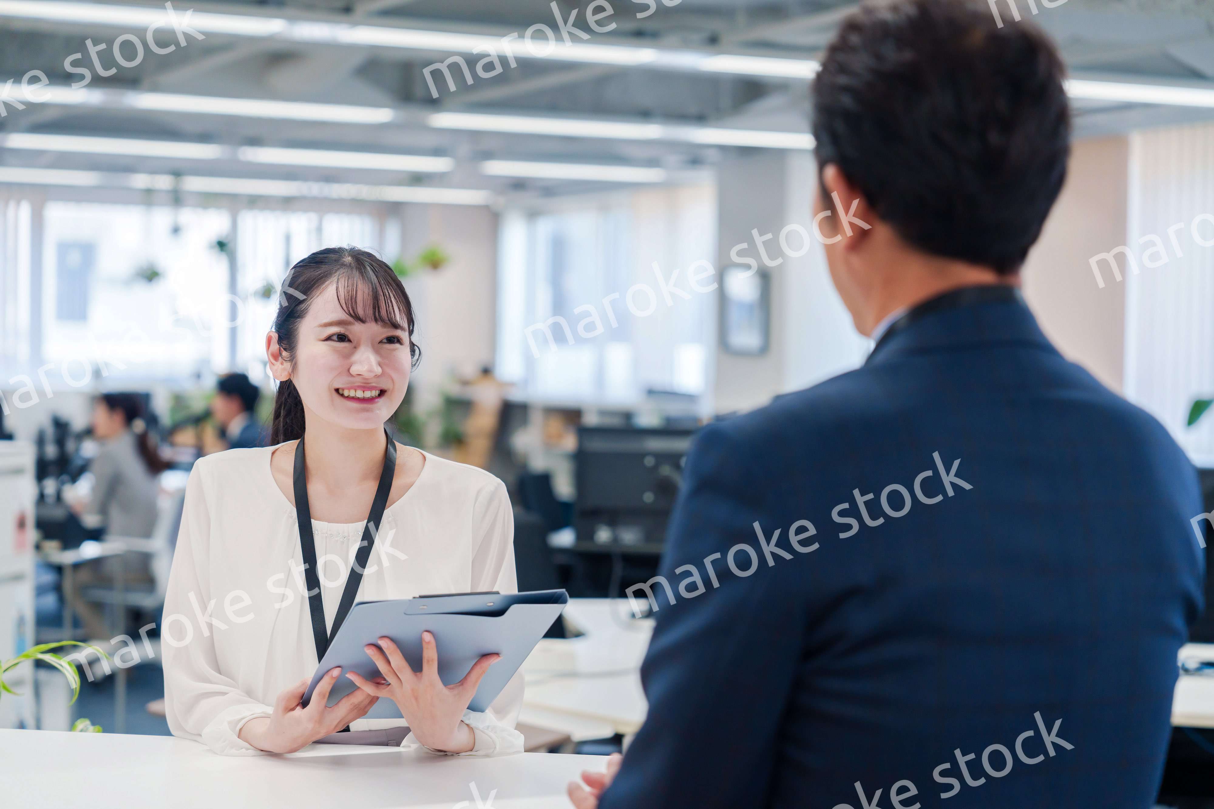窓口で来客の対応をする女性スタッフ