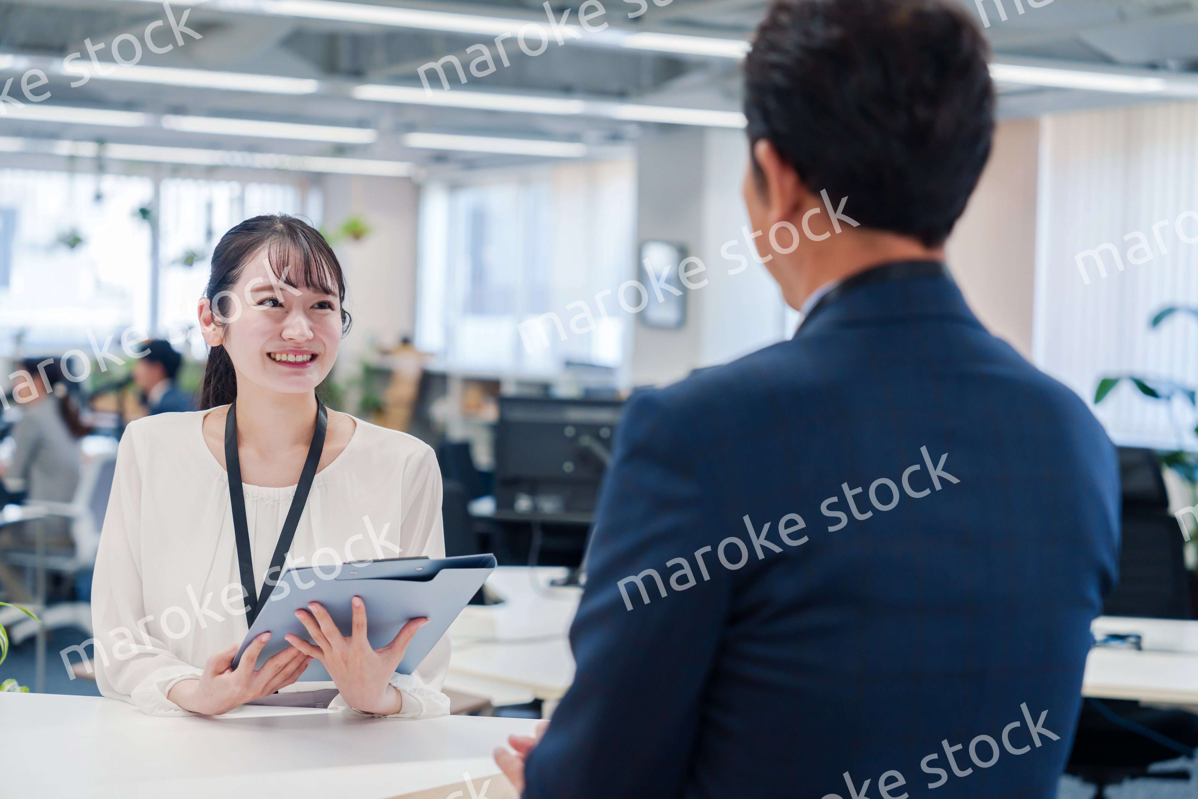 窓口で来客の対応をする女性スタッフ